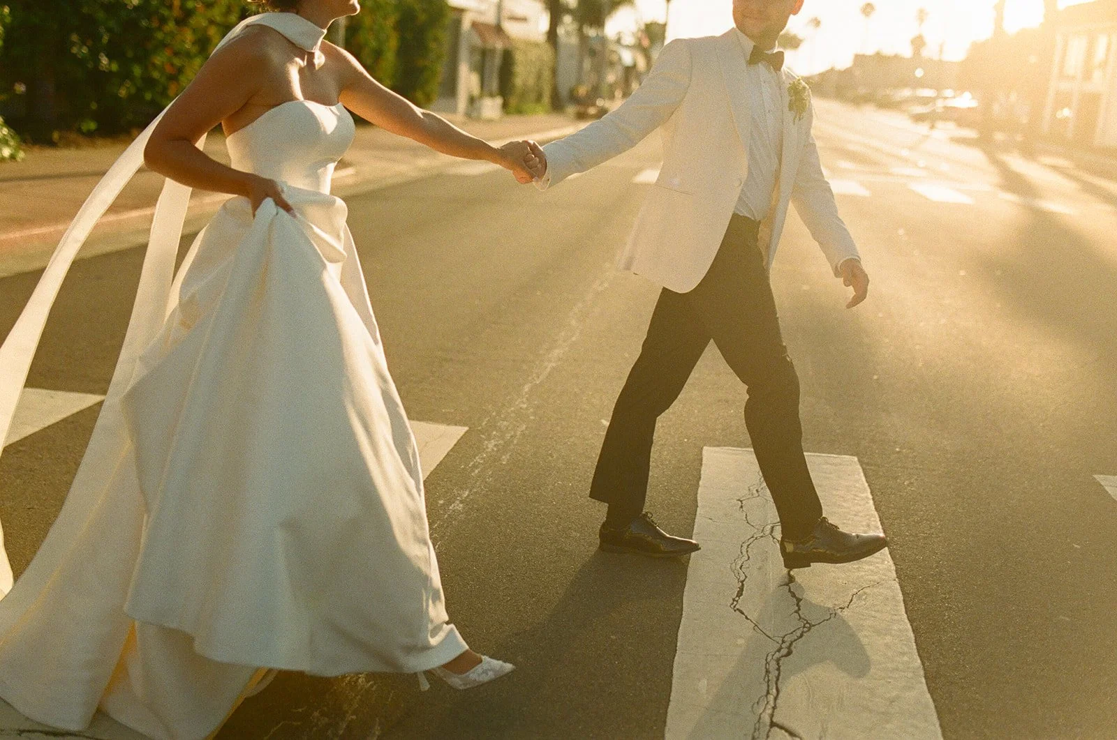 A bride and groom walking across the street at their San clemente wedding venue