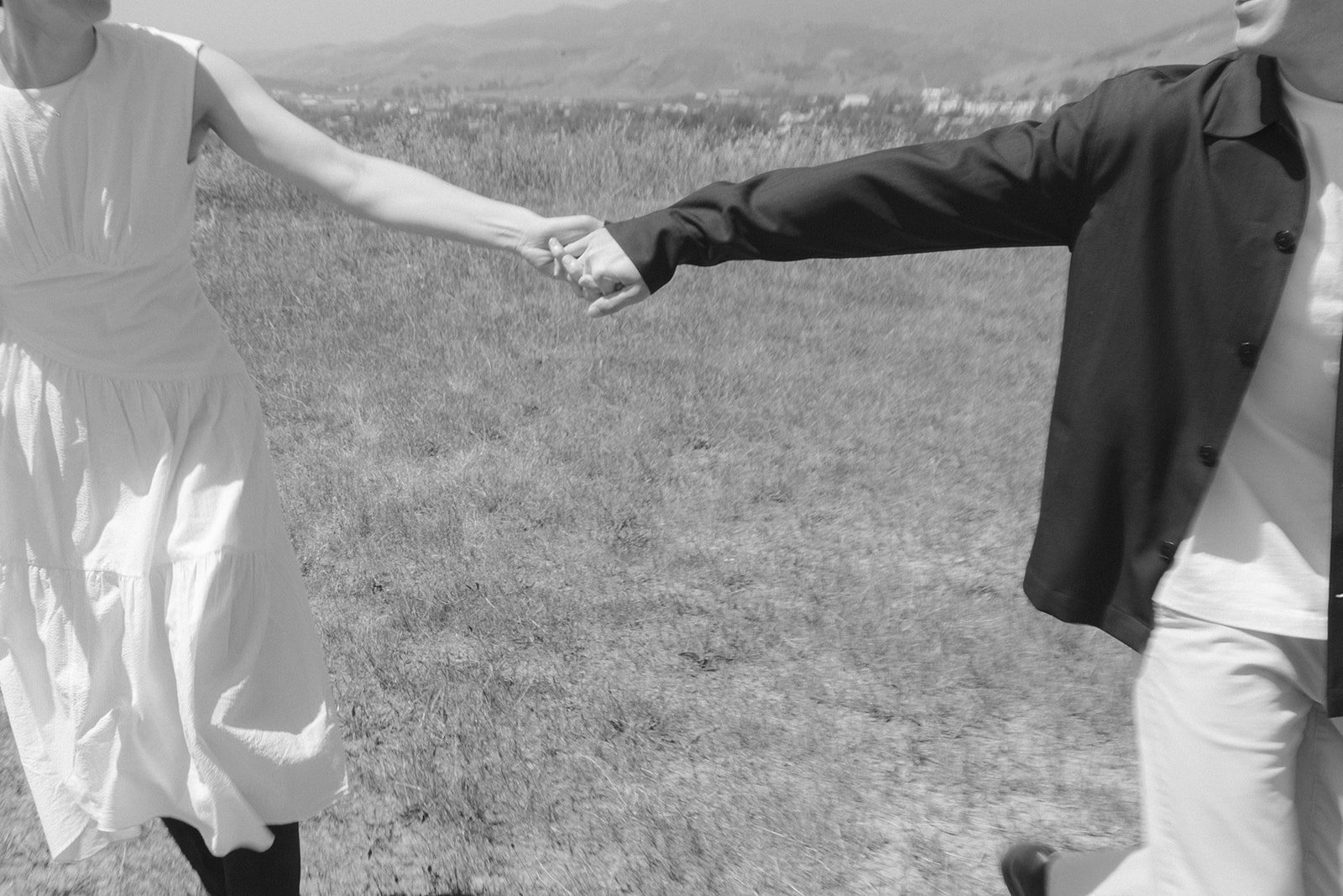 A couple running and holding hands during San Luis Obispo engagement photos