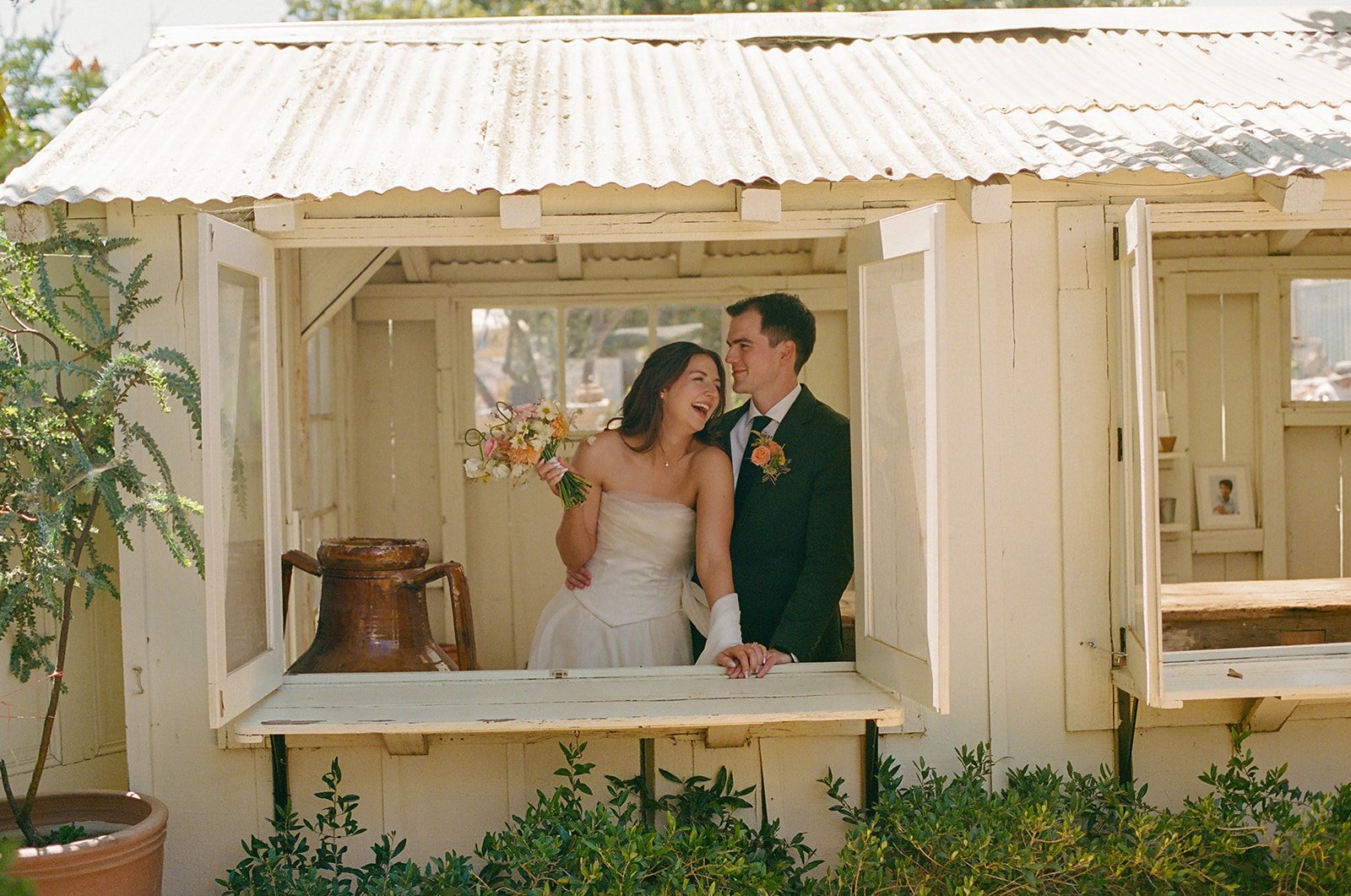 A bride and groom laughing at their small wedding venue in SoCal