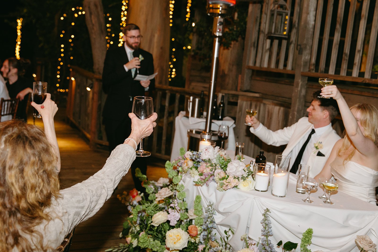 Wedding guests clinking drinks at a wedding reception