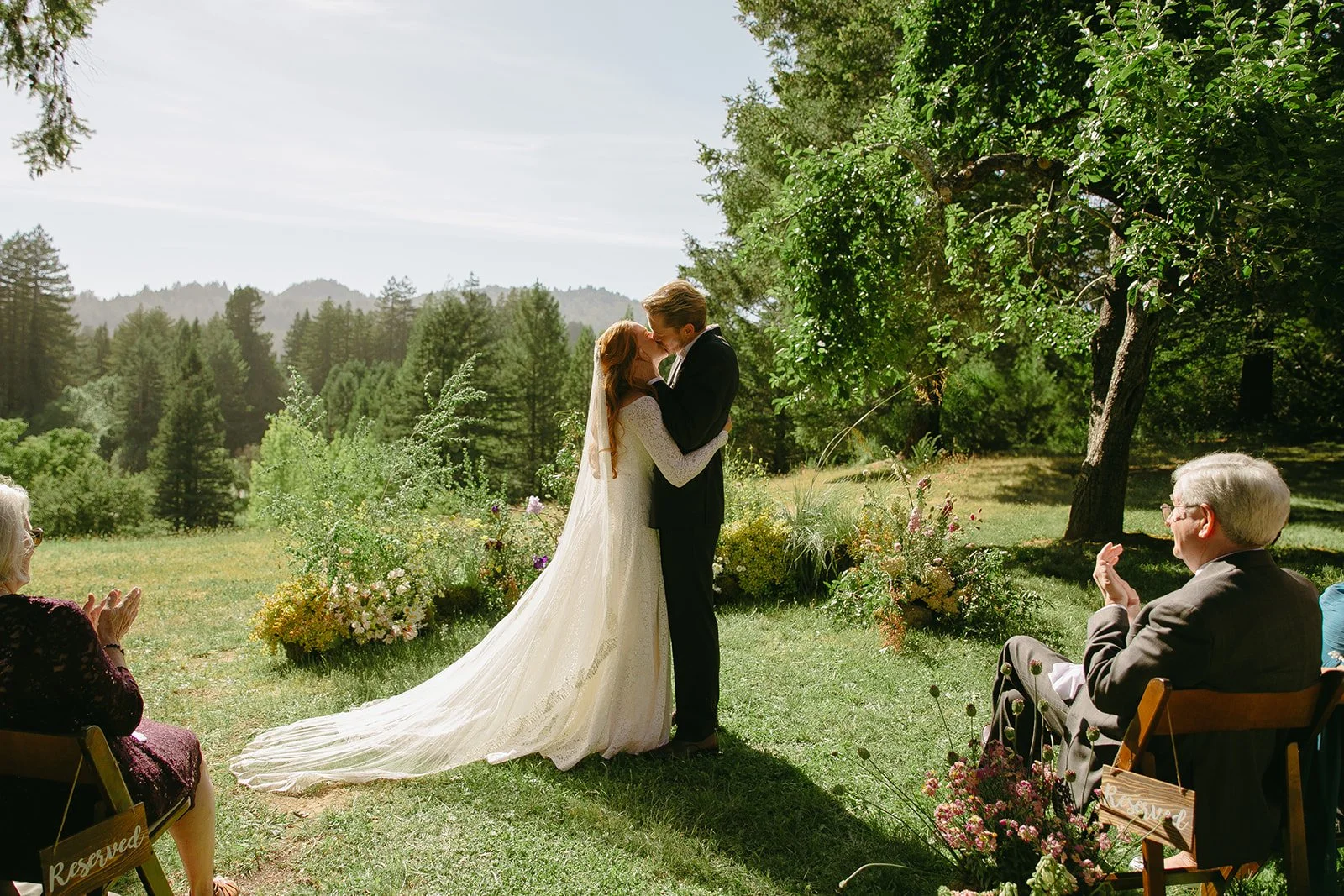 A bride and groom kissing at their garden wedding ceremony