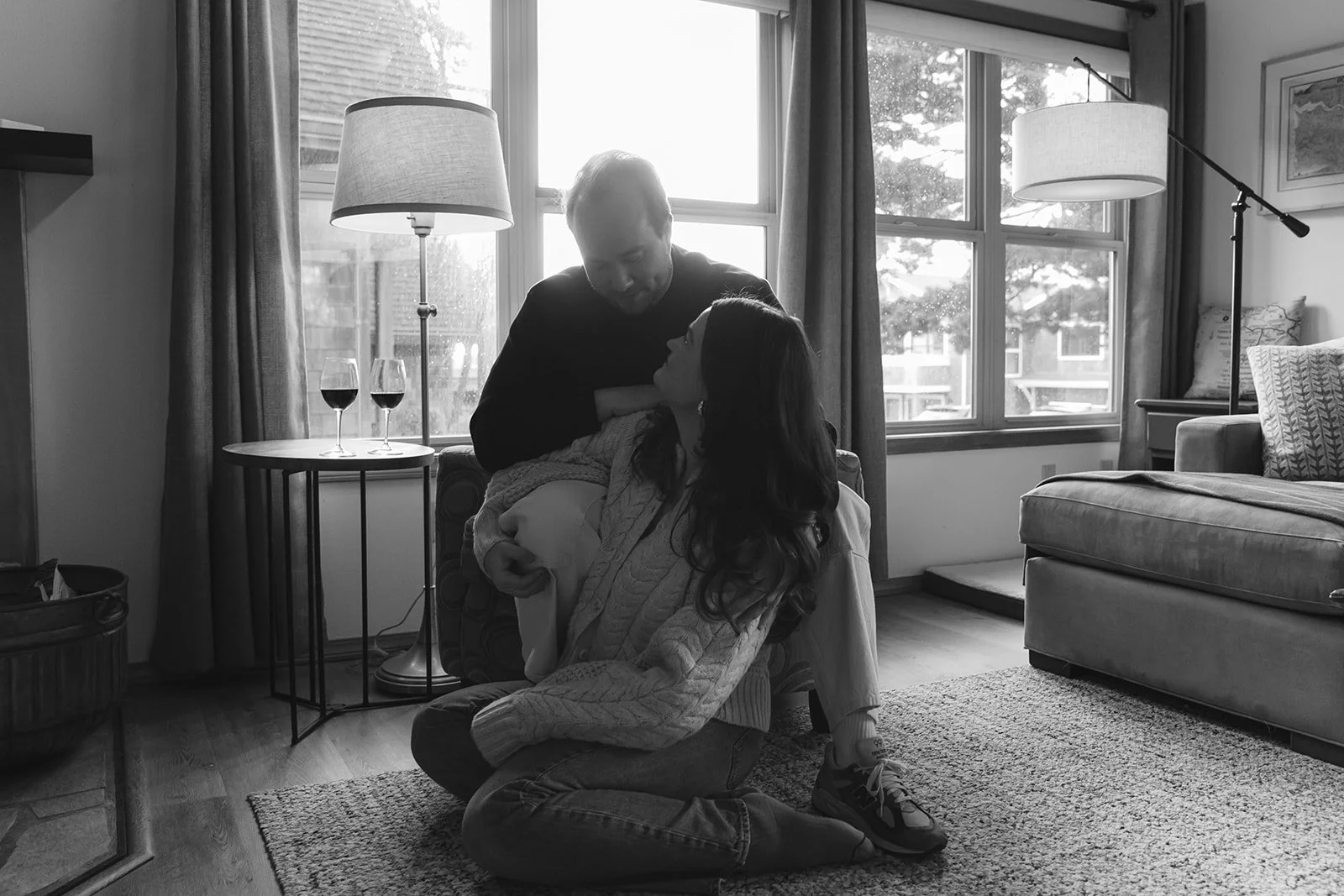 A couple in a black and white engagement photo at home