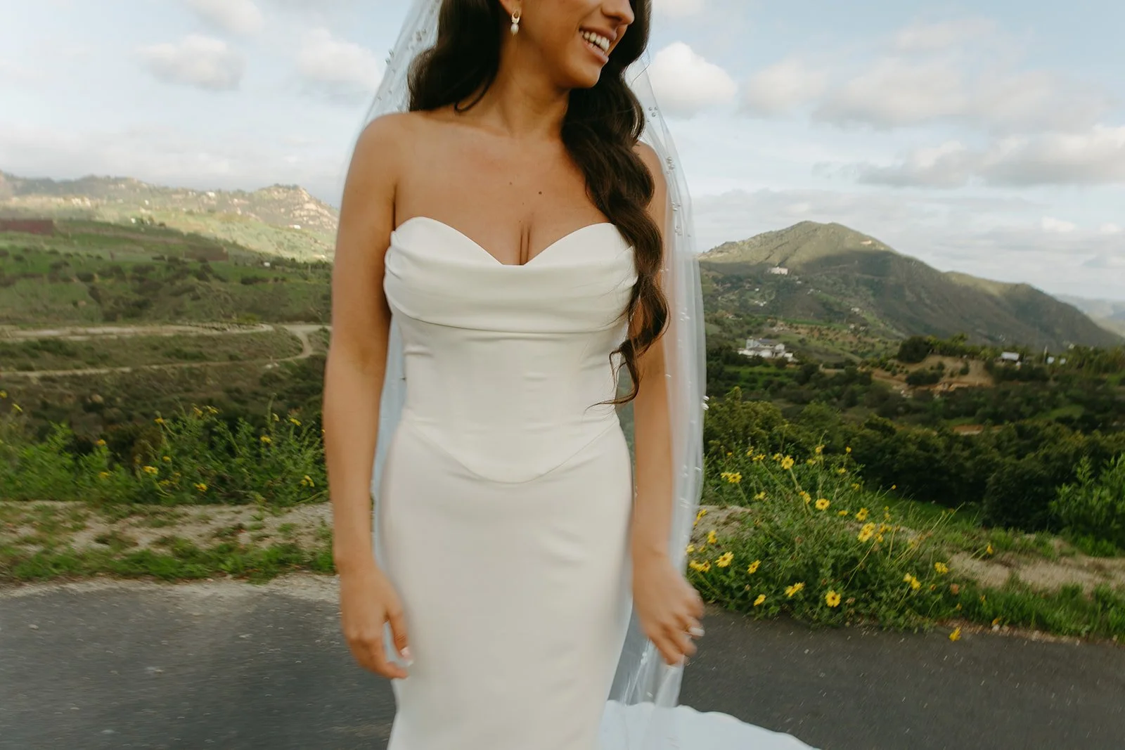 A bride posing for bridal portraits in front of the mountains
