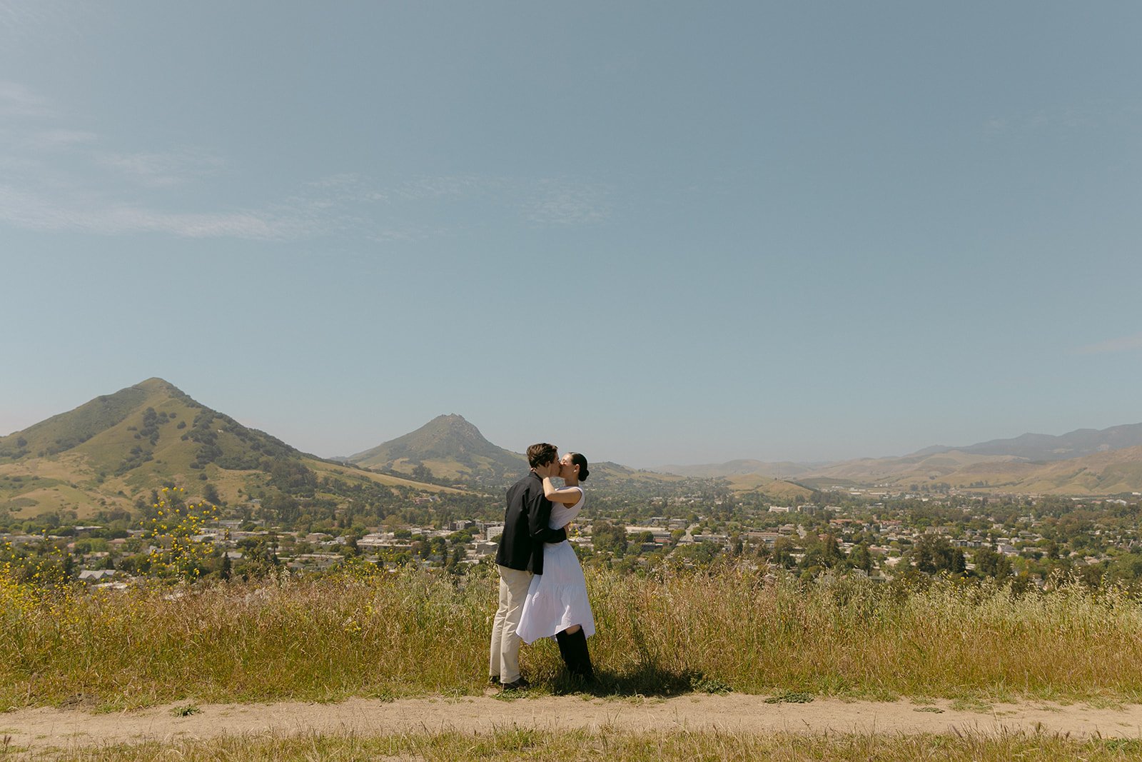 A couple kissing at the San Luis Obispo skyline