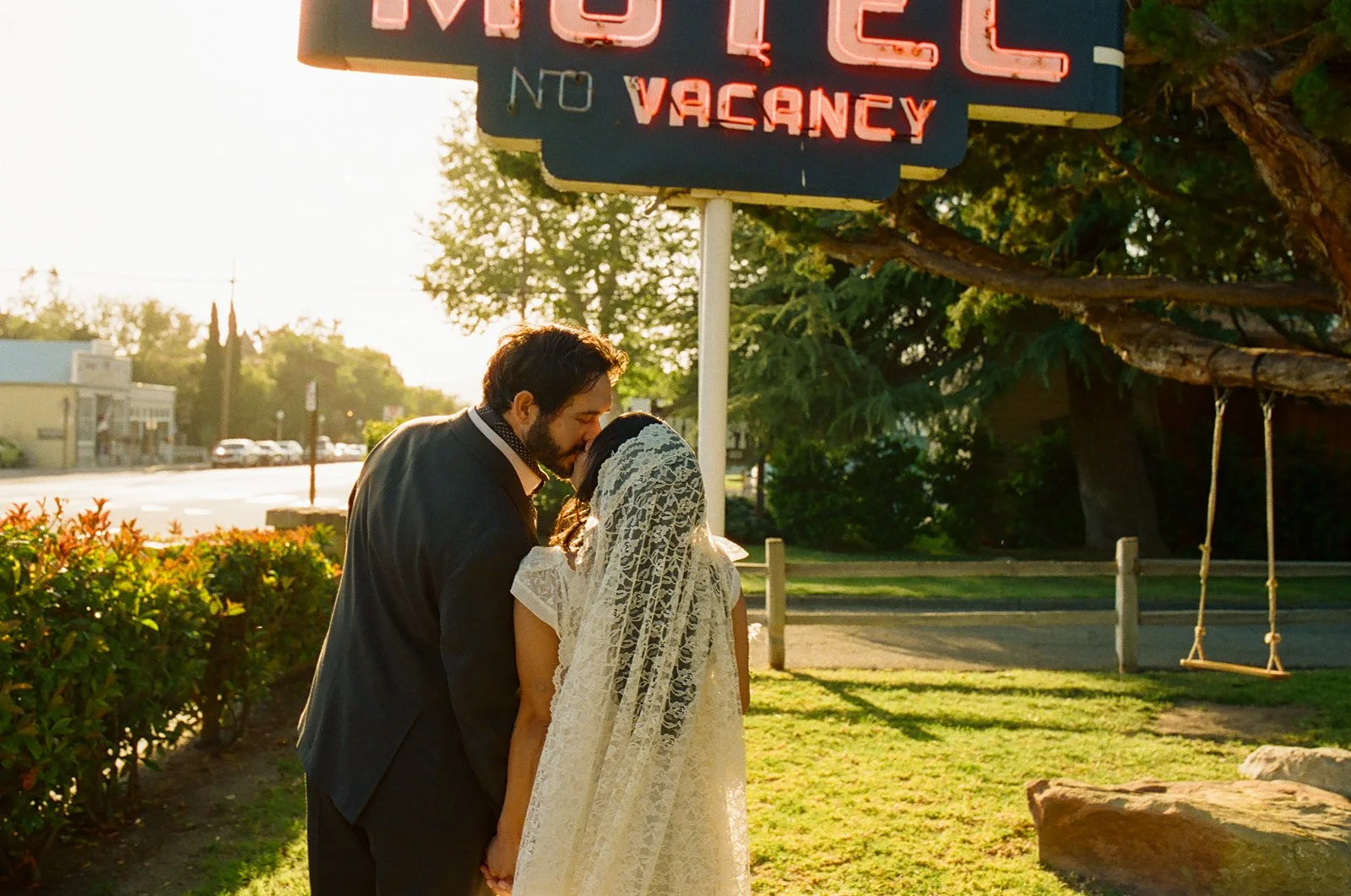 A couple kissing on the way to their dinner party wedding