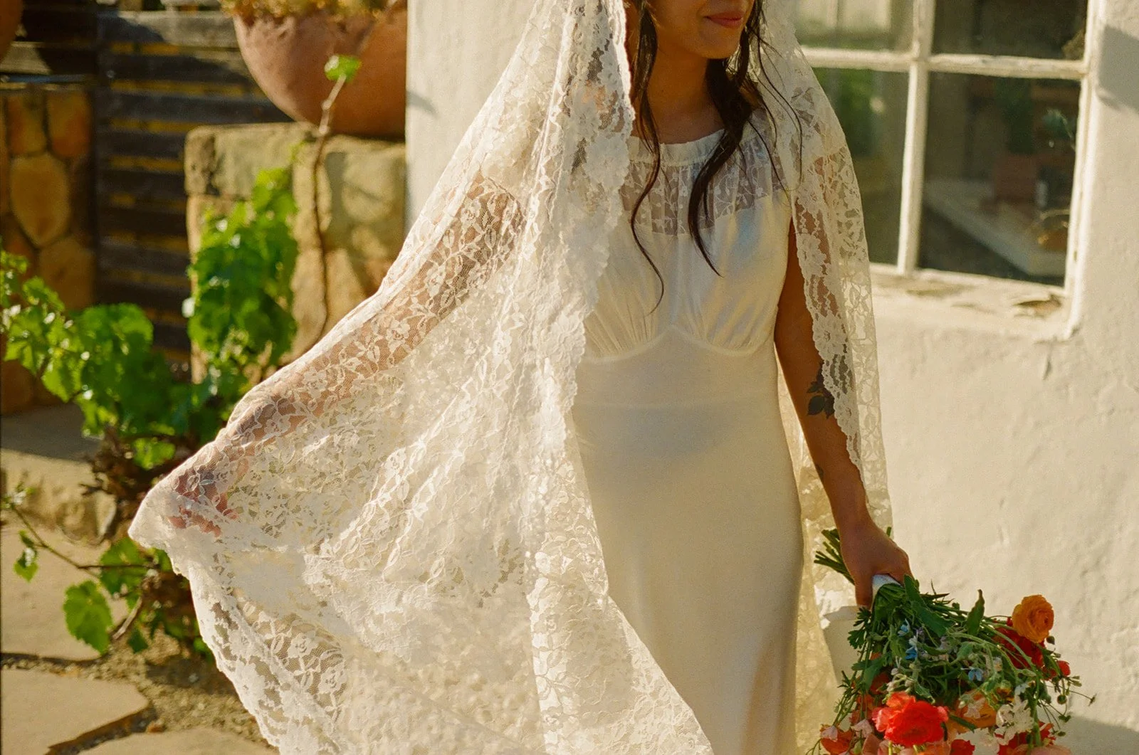 A bride posing in a vintage wedding dress and lace veil
