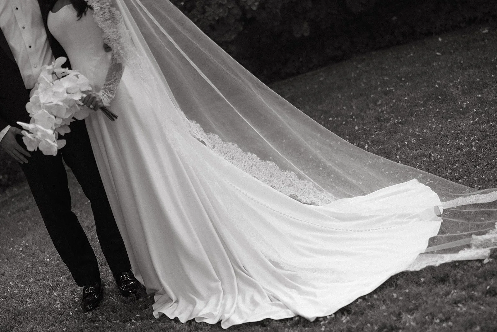 A black and white photo of a bride and groom's wedding outfits