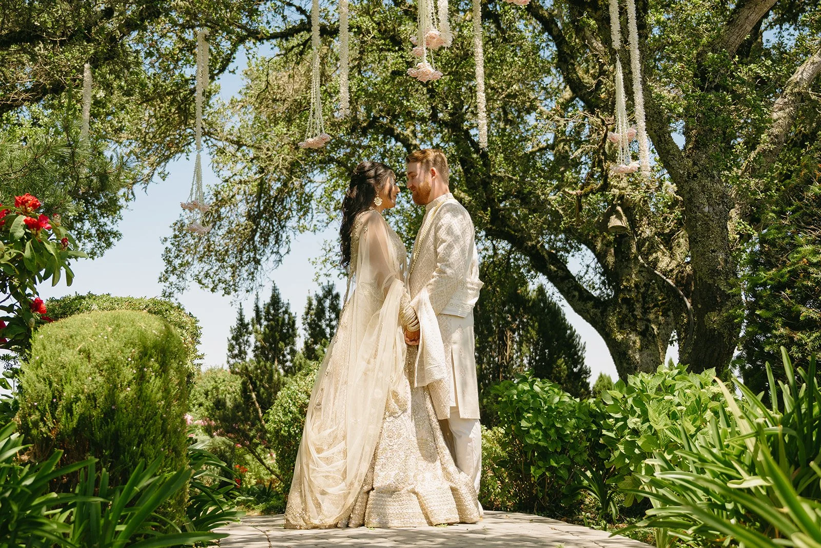 A bride and groom taking wedding photos in their traditional Indian wedding attire