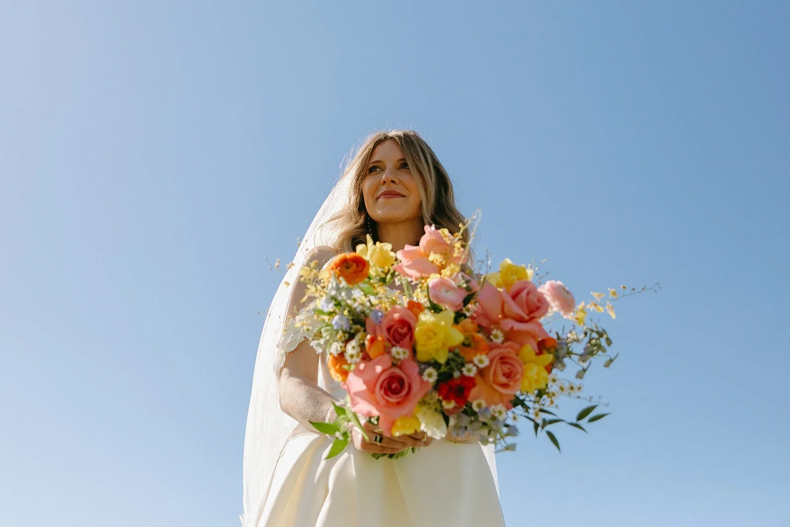 A bride holding a colorful wedding bouquet