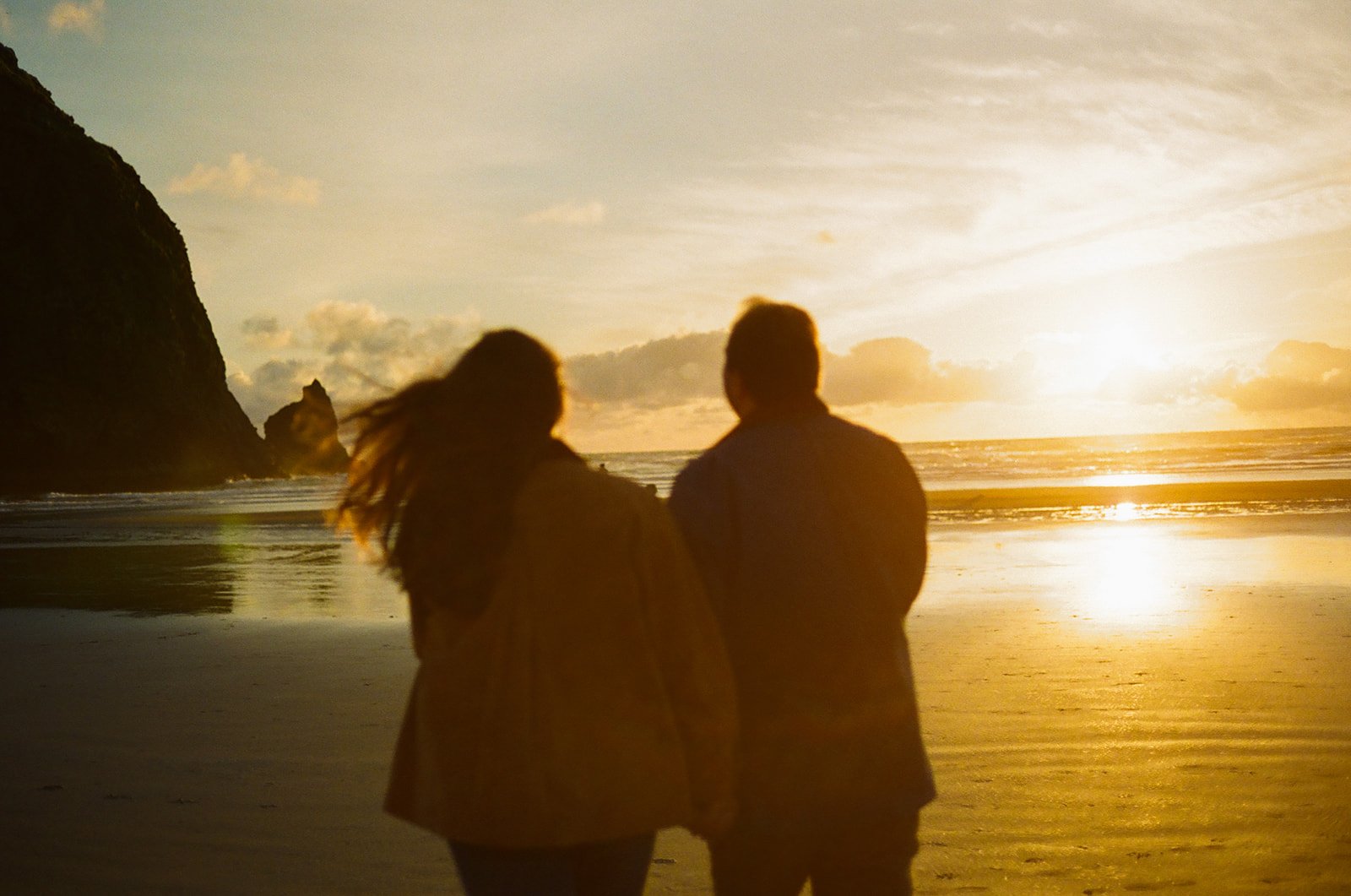 A couple on cannon beach after choosing where to take engagement photos