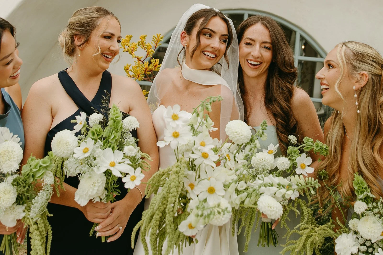 A bride and bridesmaids taking wedding photos