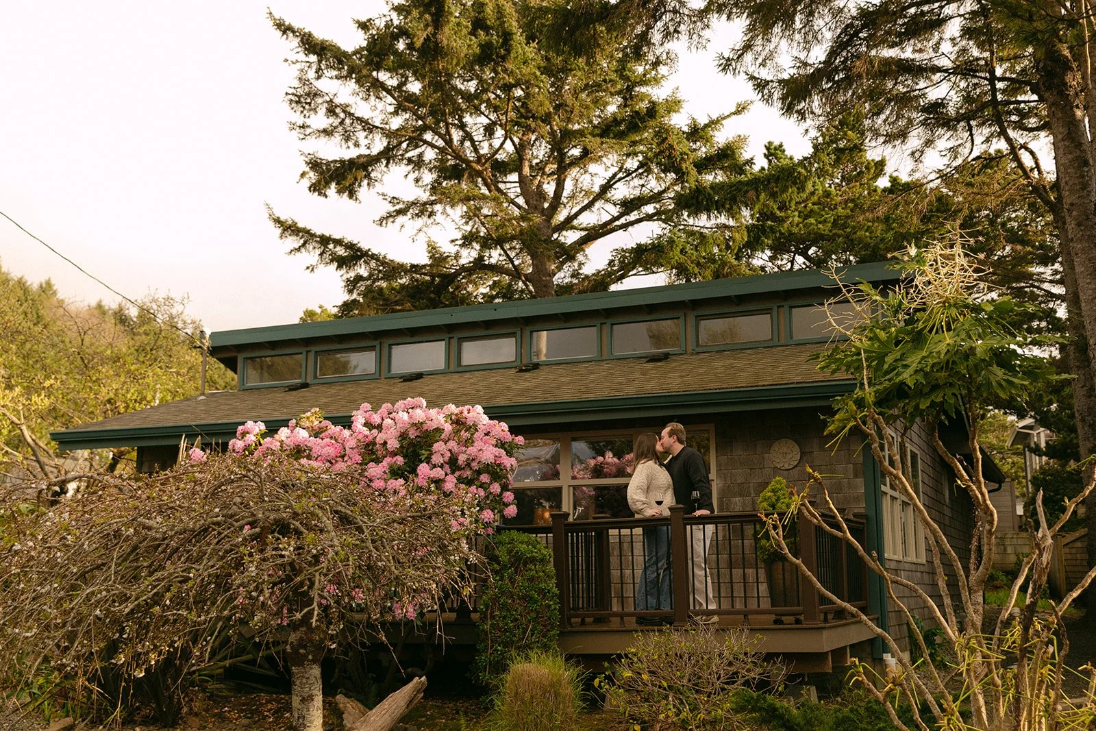 A couple taking engagement photos on a porch at a family home