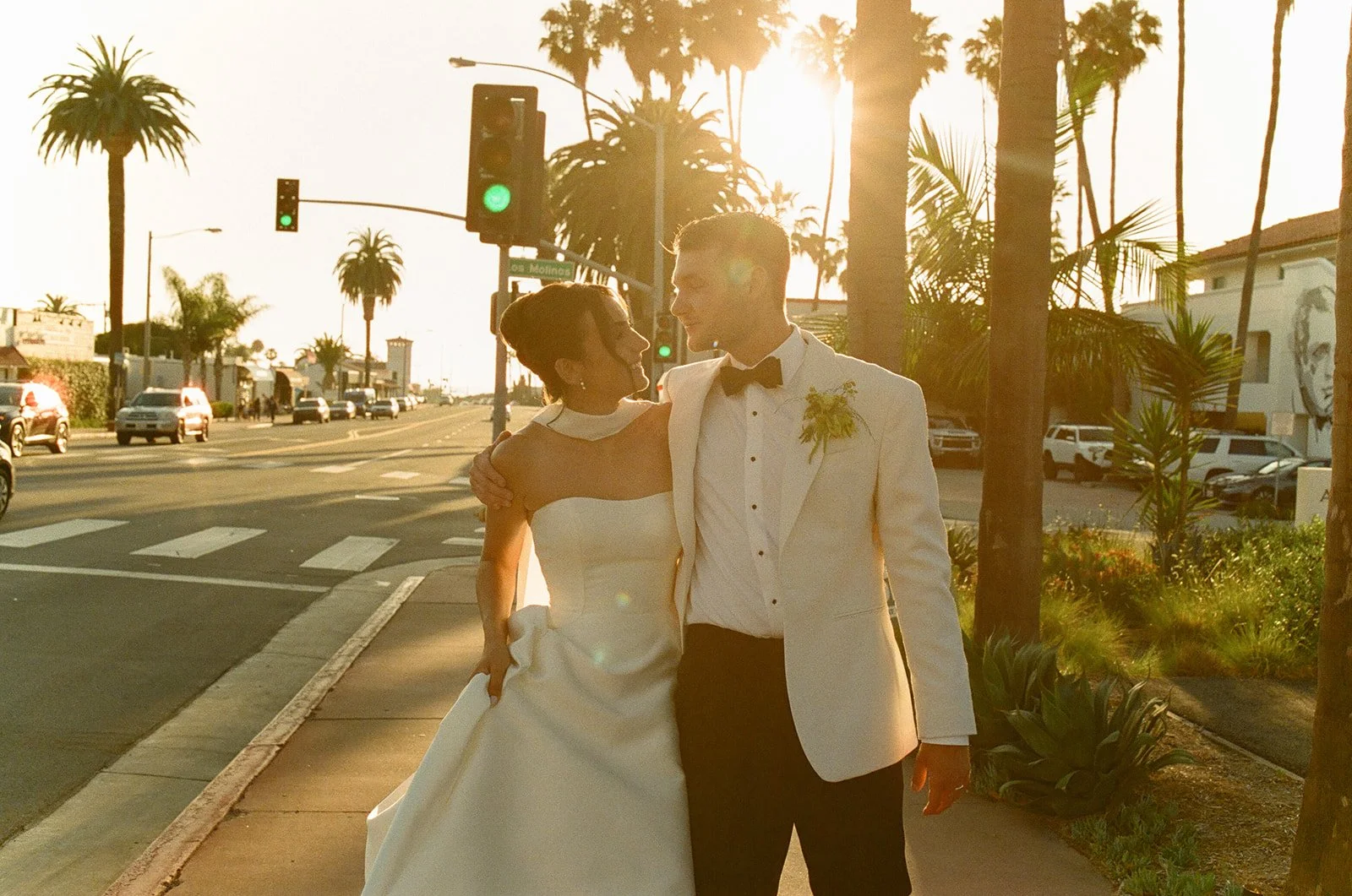 A bride and groom taking sunset wedding photos on a crosswalk