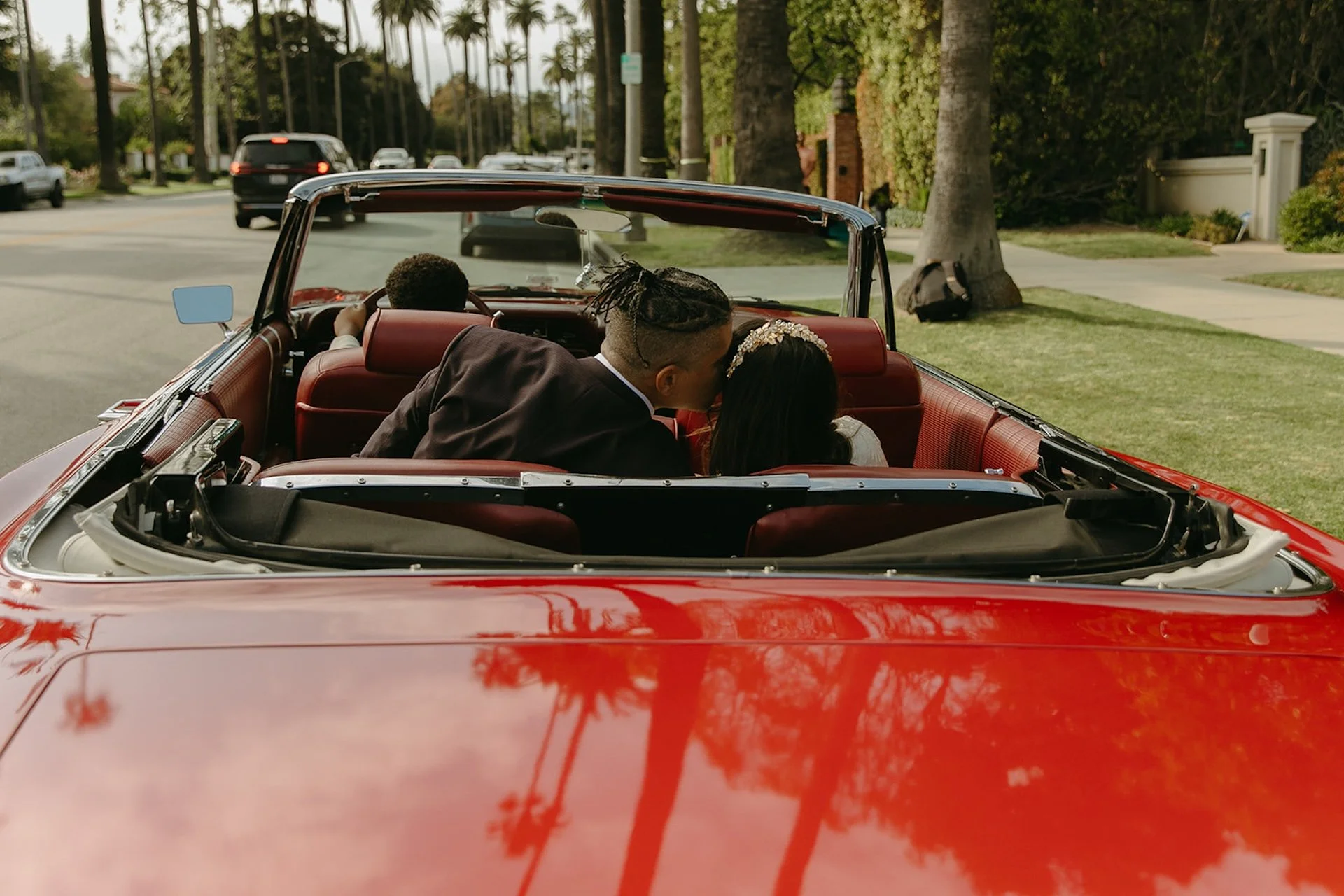 Newlyweds sitting in the backseat of a red convertable after their Beverly Hills Courthouse Elopement