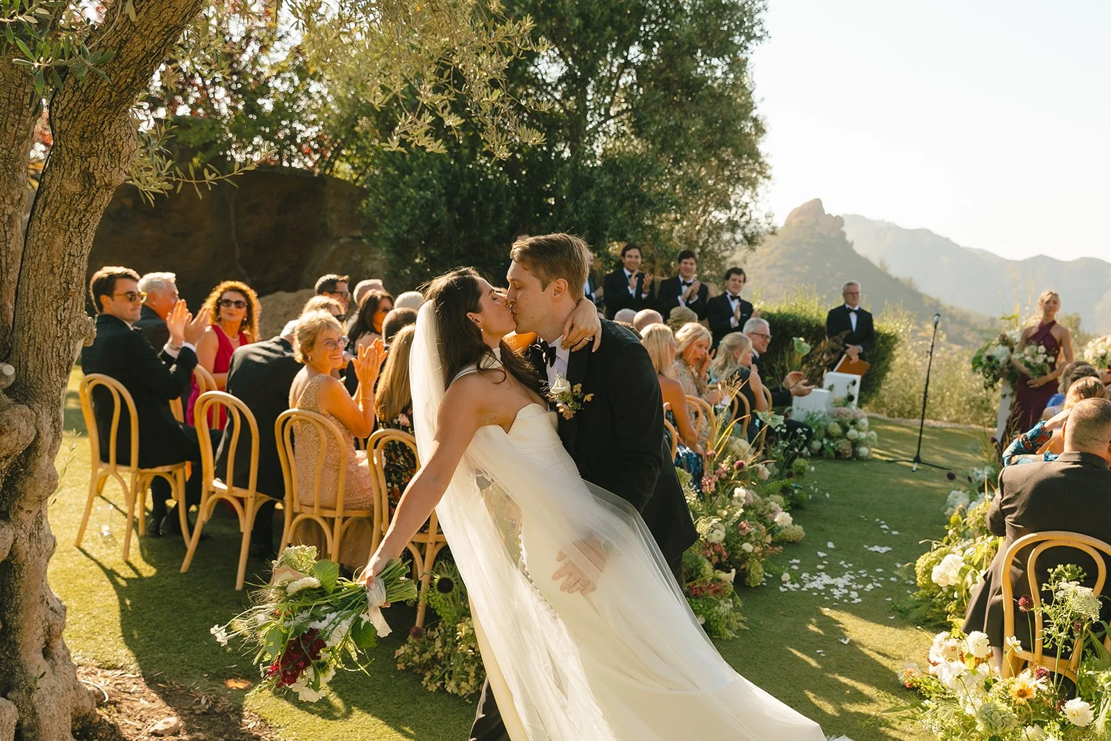 A bride and groom kissing after their wedding ceremony
