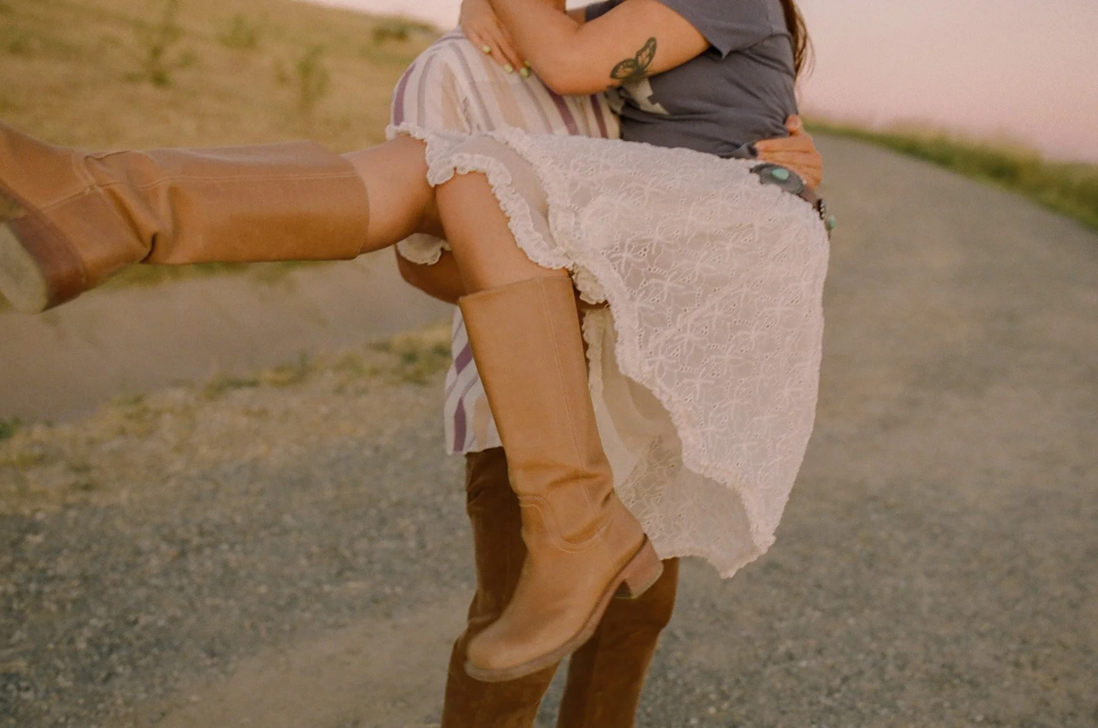 A man holding his fiancee for engagement photo poses