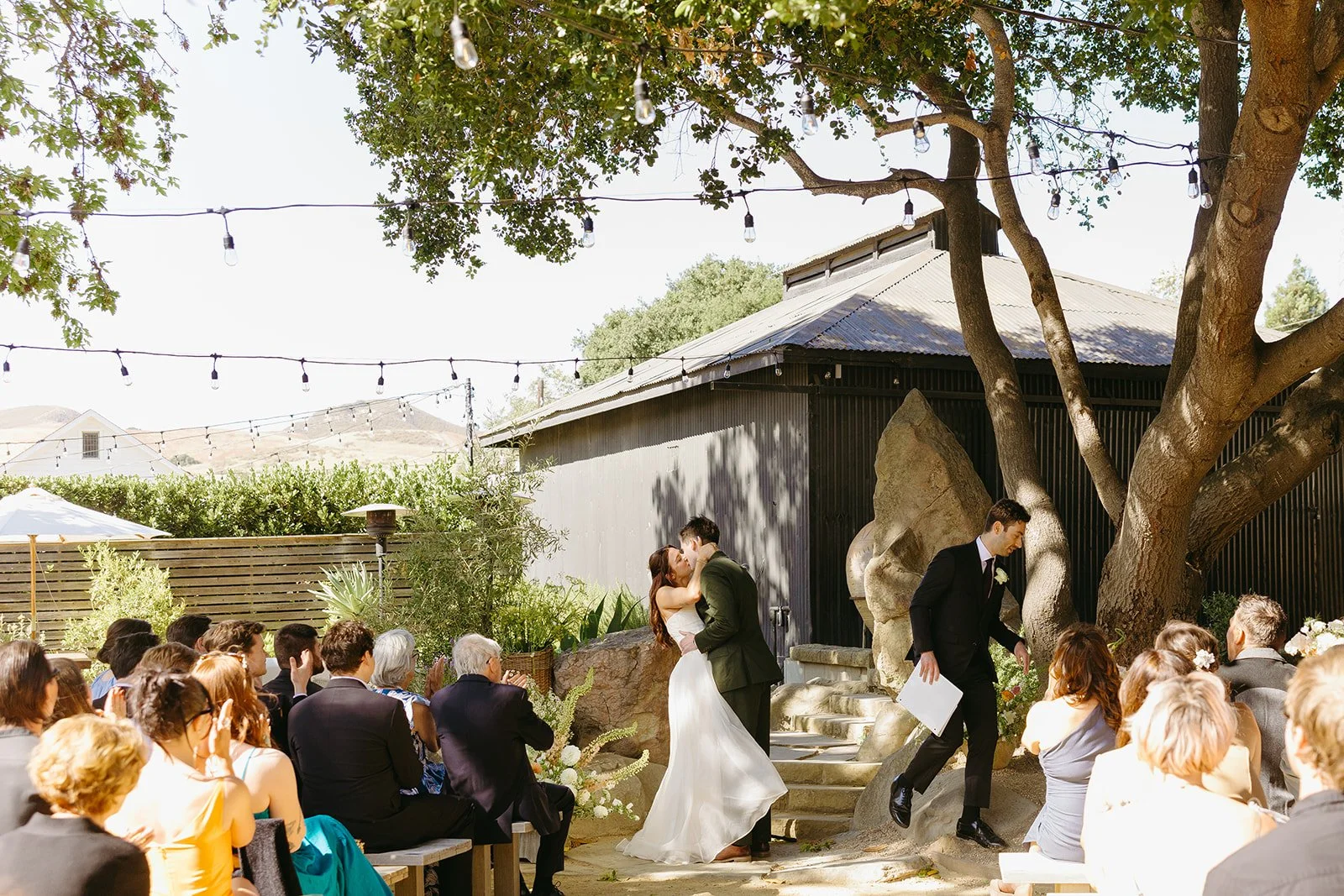 A bride and groom kissing in their wedding ceremony