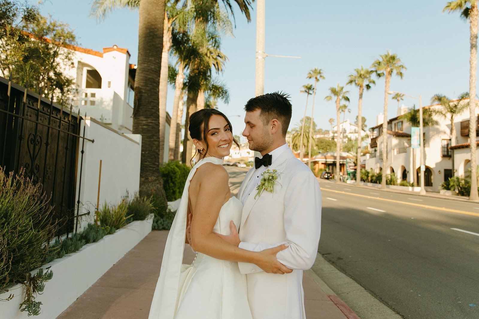 A bride and groom posing for street wedding photos