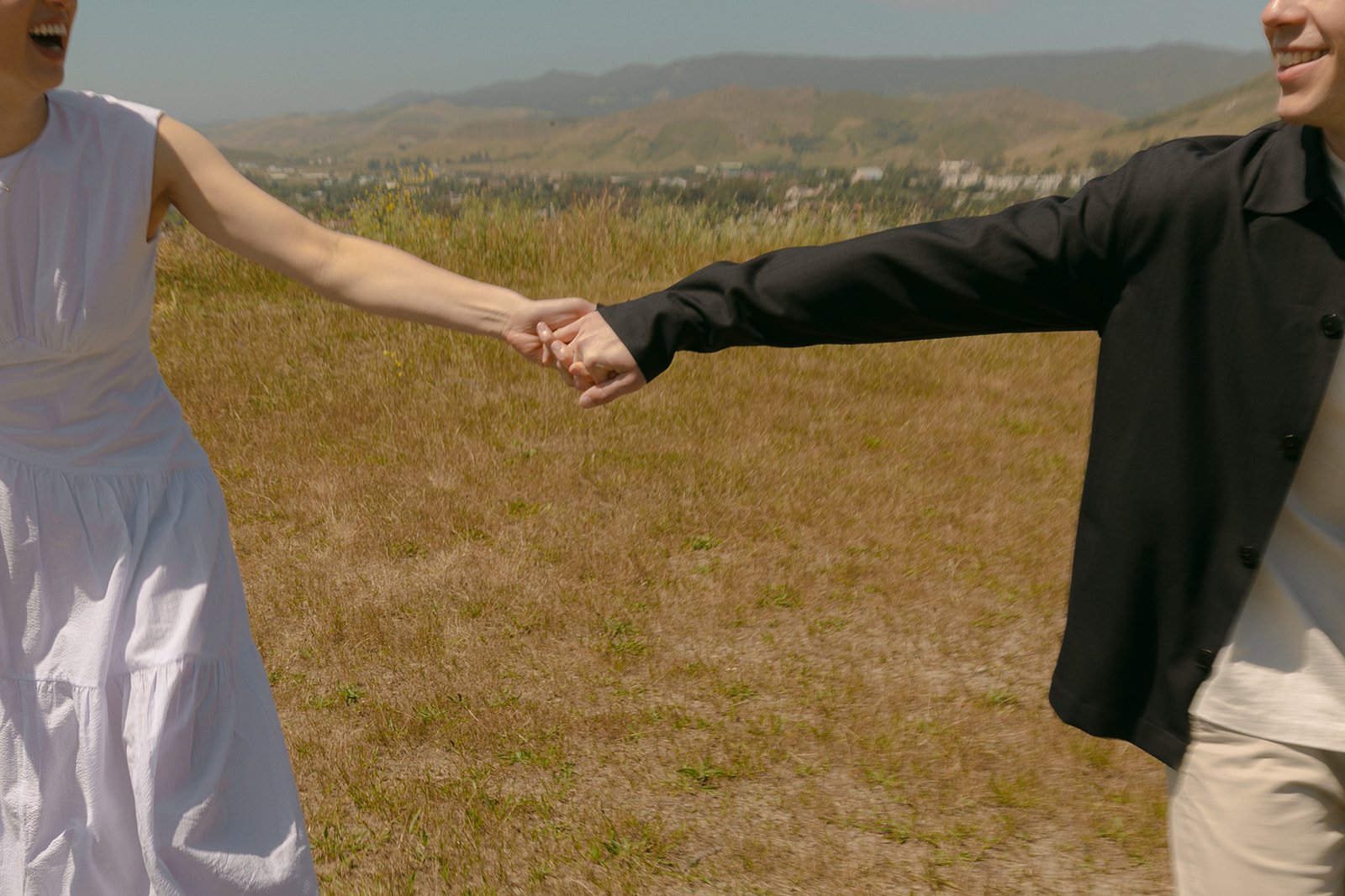 A couple holding hands during SLO engagement photos