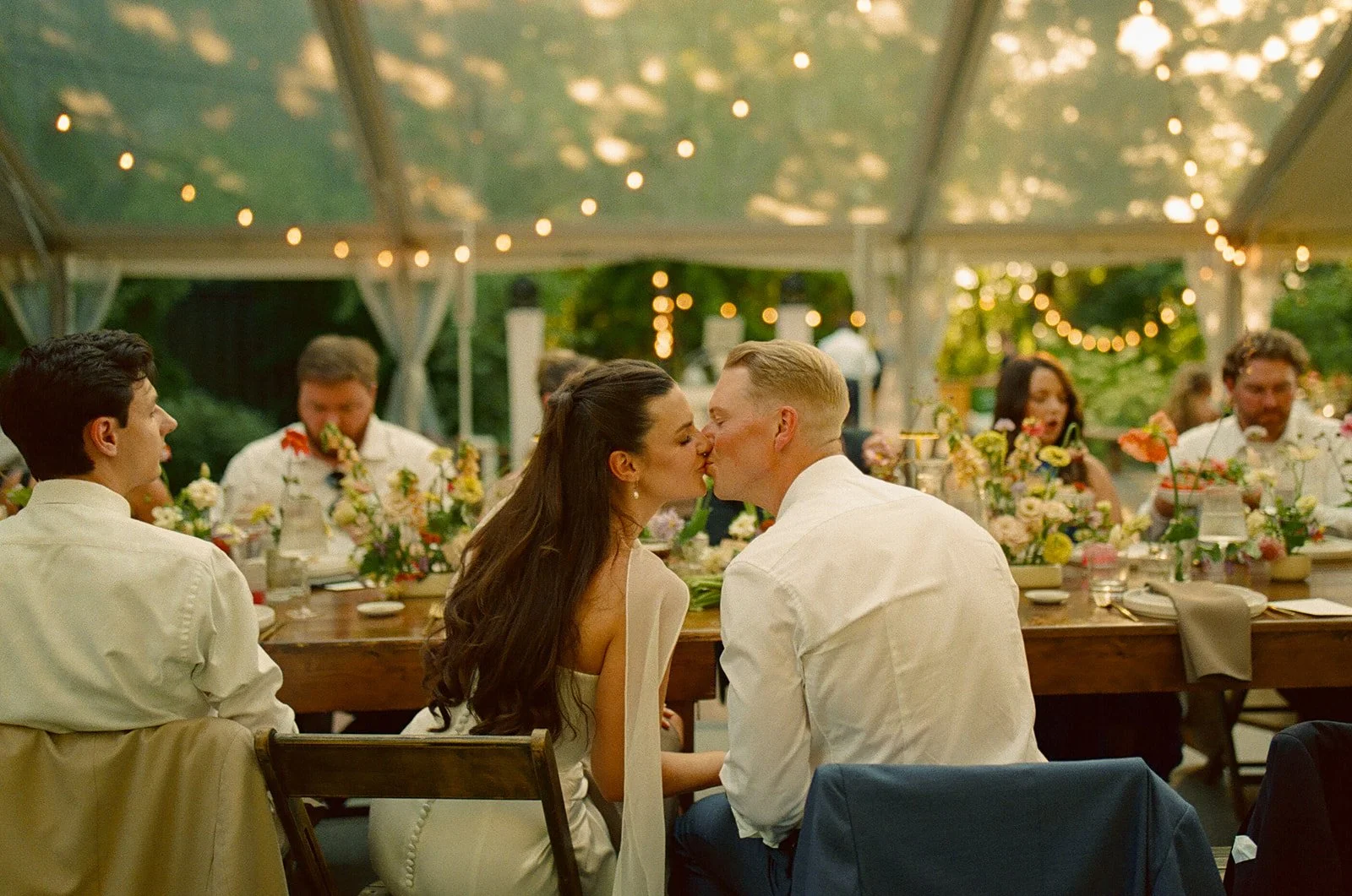 A bride and groom kissing at their wedding reception