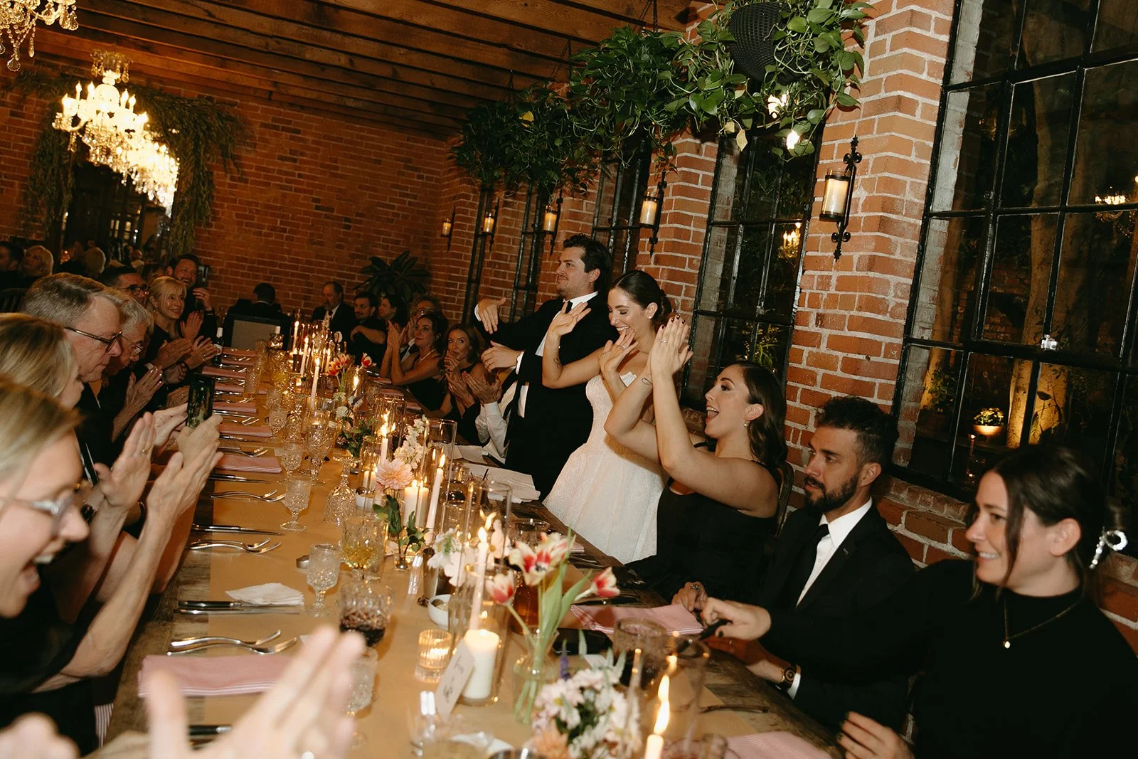 The bride and groom clapping at their speeches during their wedding dinner at a DTLA wedding venue