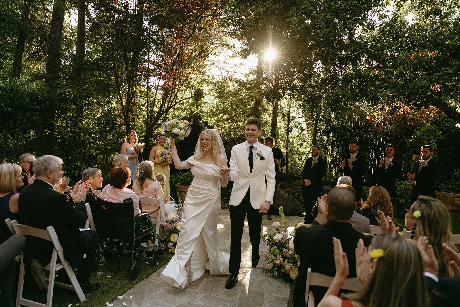 A bride and groom cheering after their Calamigos Ranch wedding ceremony