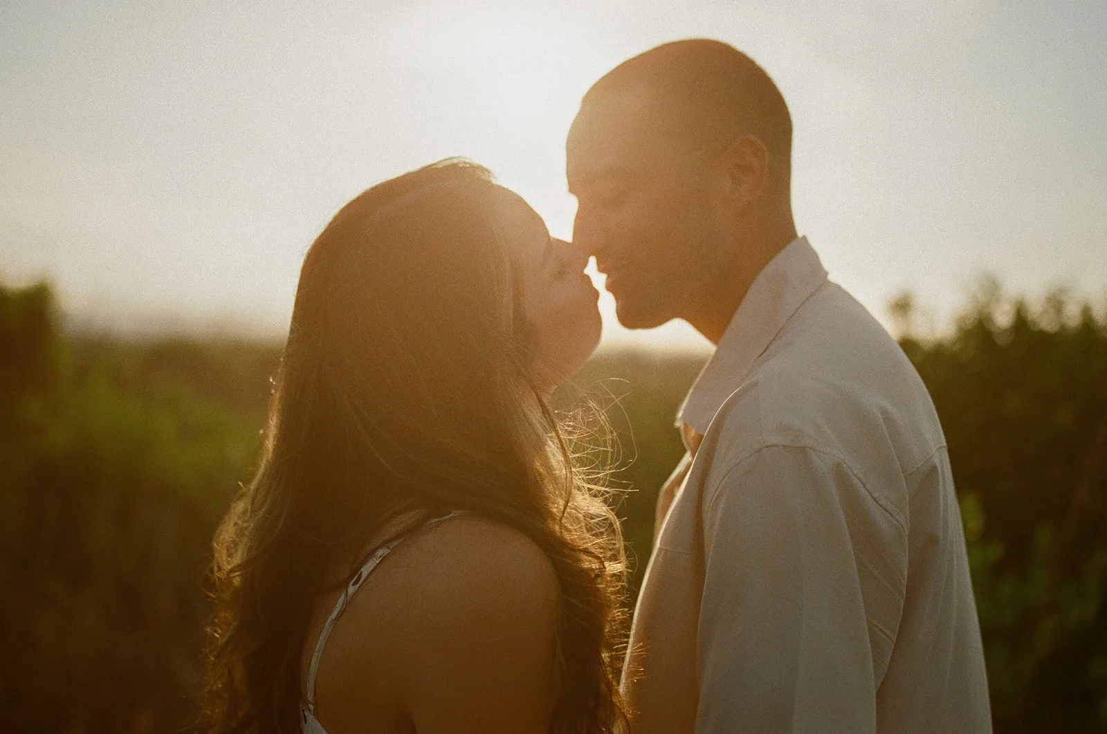 A couple leaning in for a kiss during their beach engagement photos