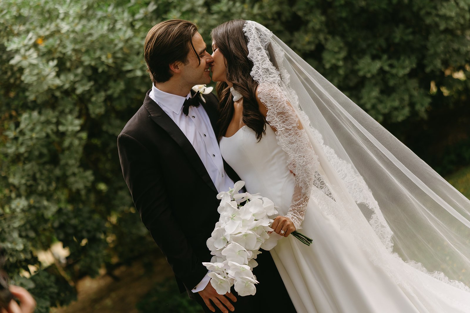 A bride and groom kissing during wedding photos