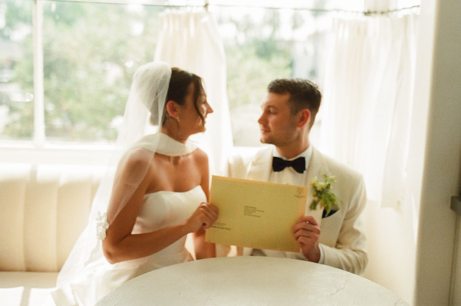 A bride and groom holding up their marriage license