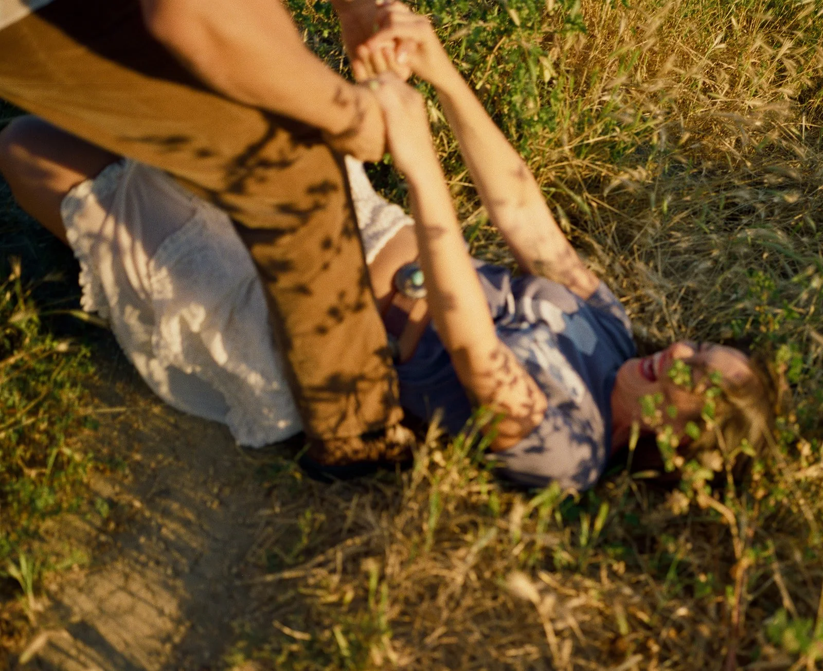 A girl laughing on the ground during her film engagement photos