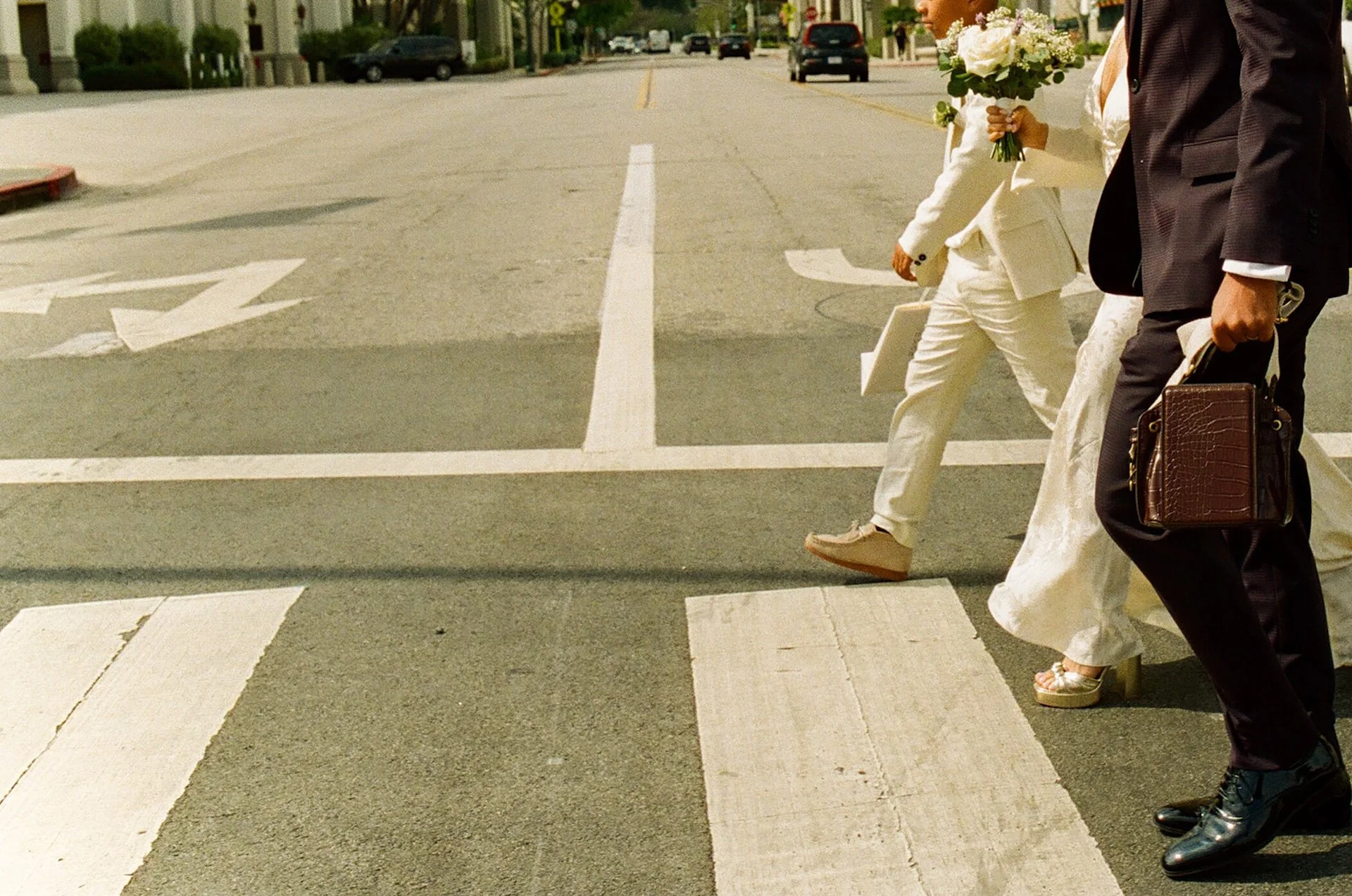 Editorial photo of the newlyweds and their sun walking across a street in Beverly Hills