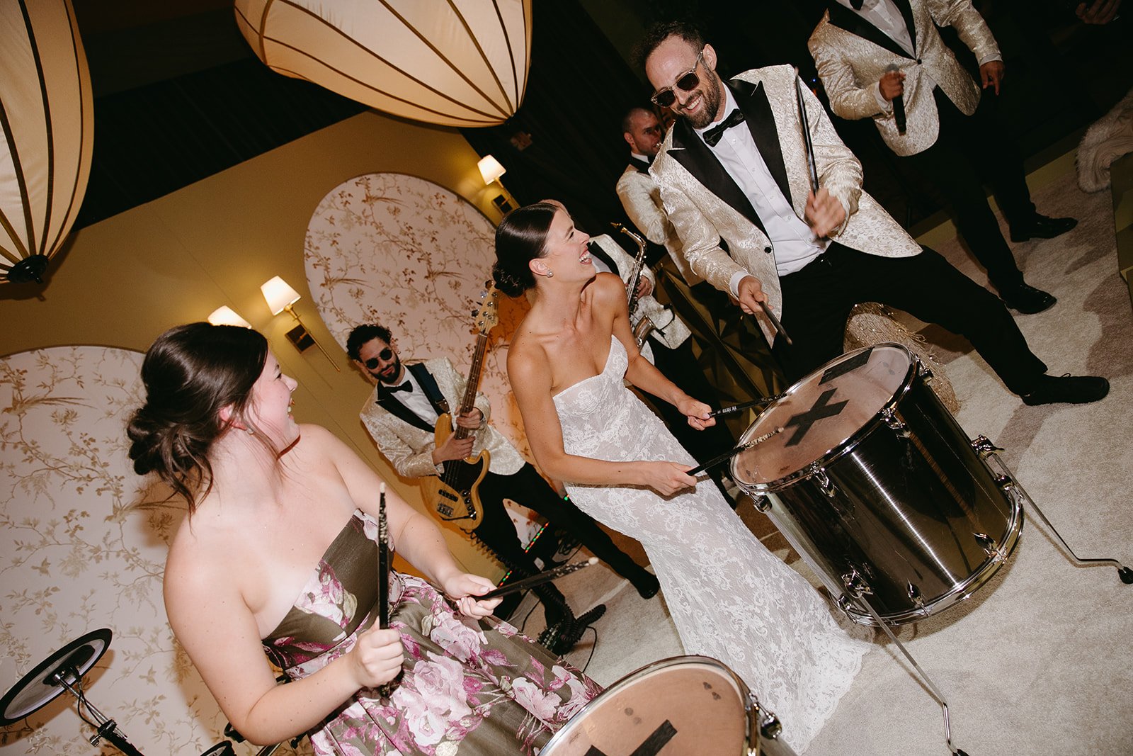 A bride playing drums with her wedding live band