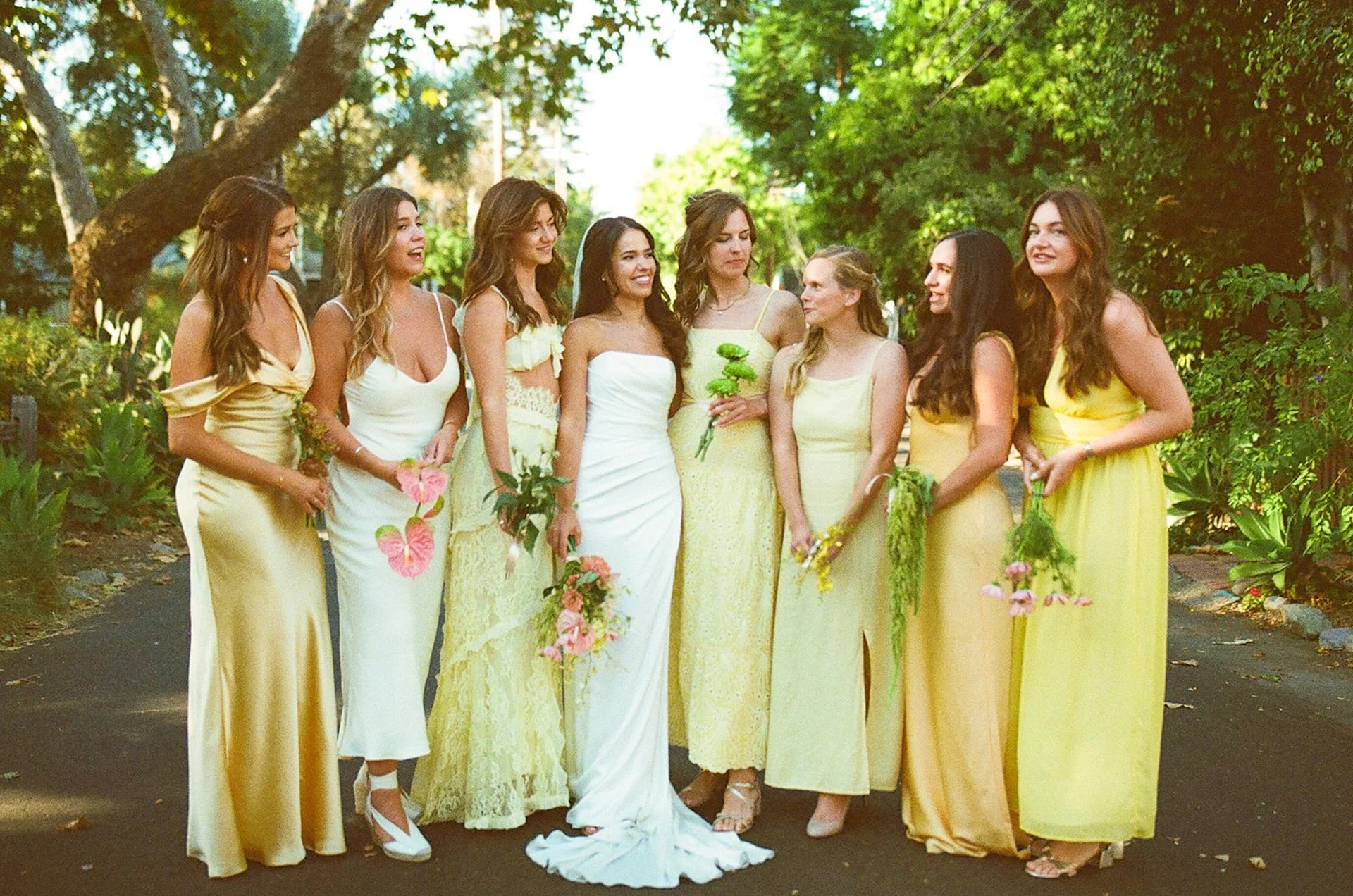 A film photo of the bride and bridesmaids standing in the middle of a street for wedding party photos.