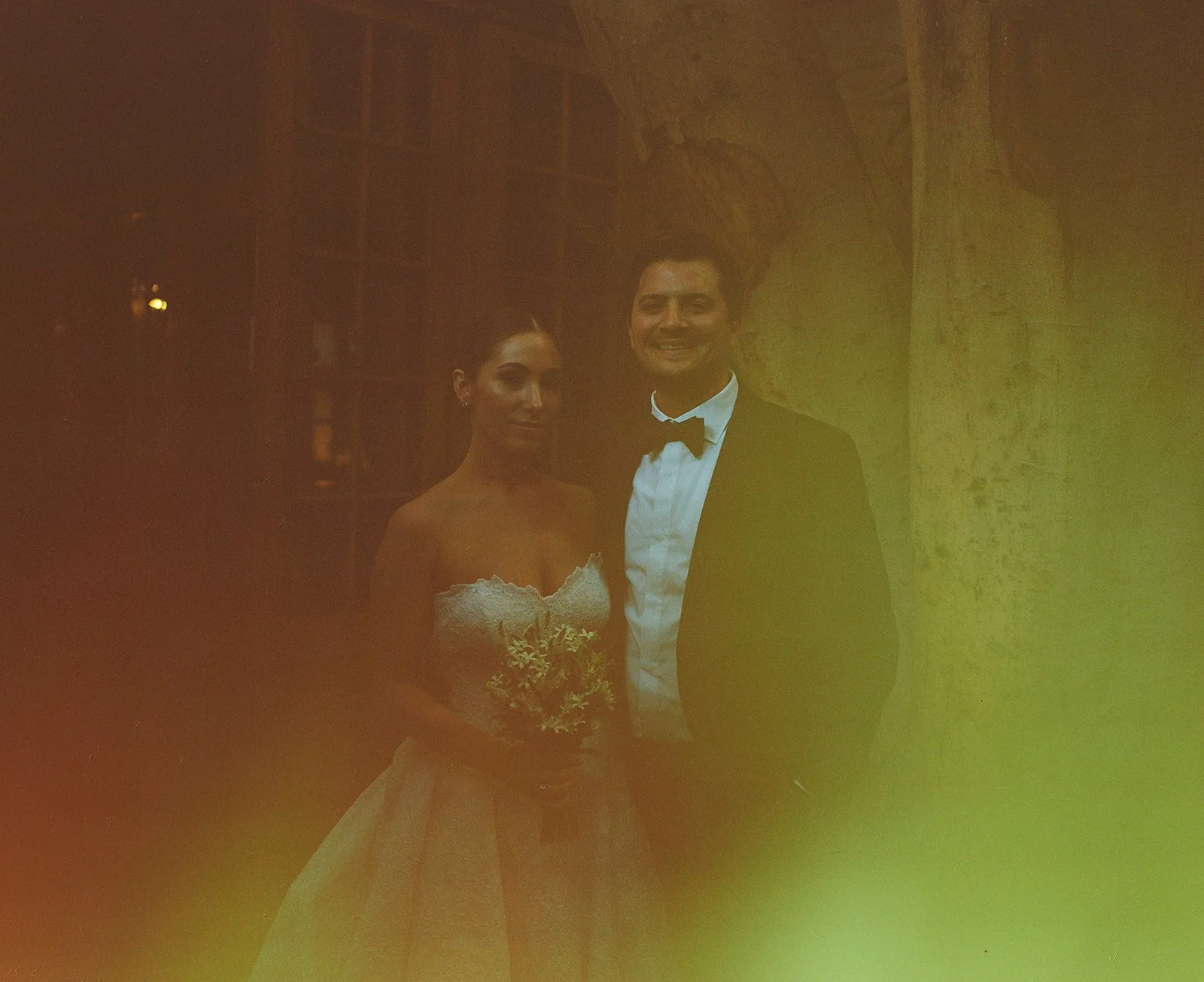 A film photo of the bride and groom smiling at the photographer in the courtyard at their unique DTLA wedding venue