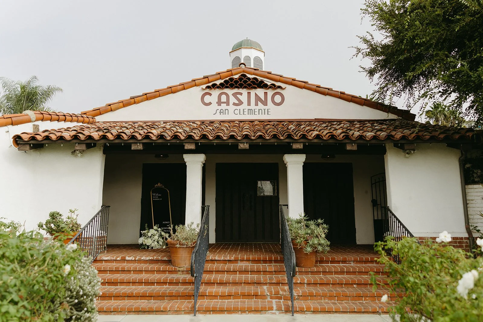 Wide exterior view of Casino San Clemente with Spanish-inspired architecture, tiled roof, and classic white facade.