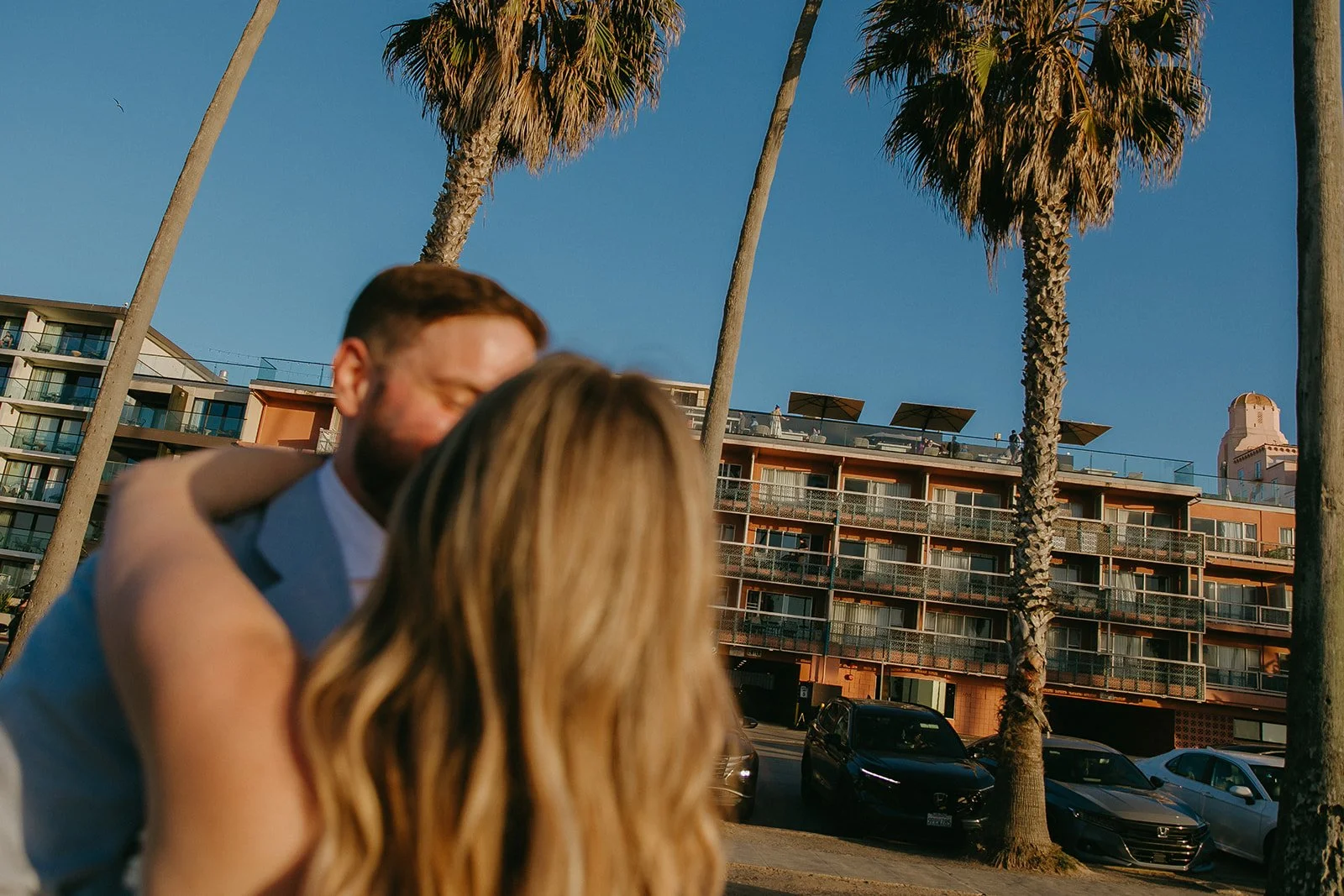 A bride and groom hugging in front of their unique wedding venue