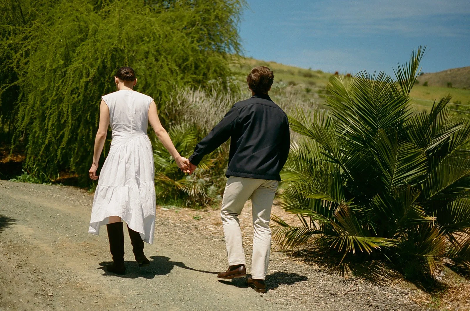 A couple holding hands in garden engagement photos