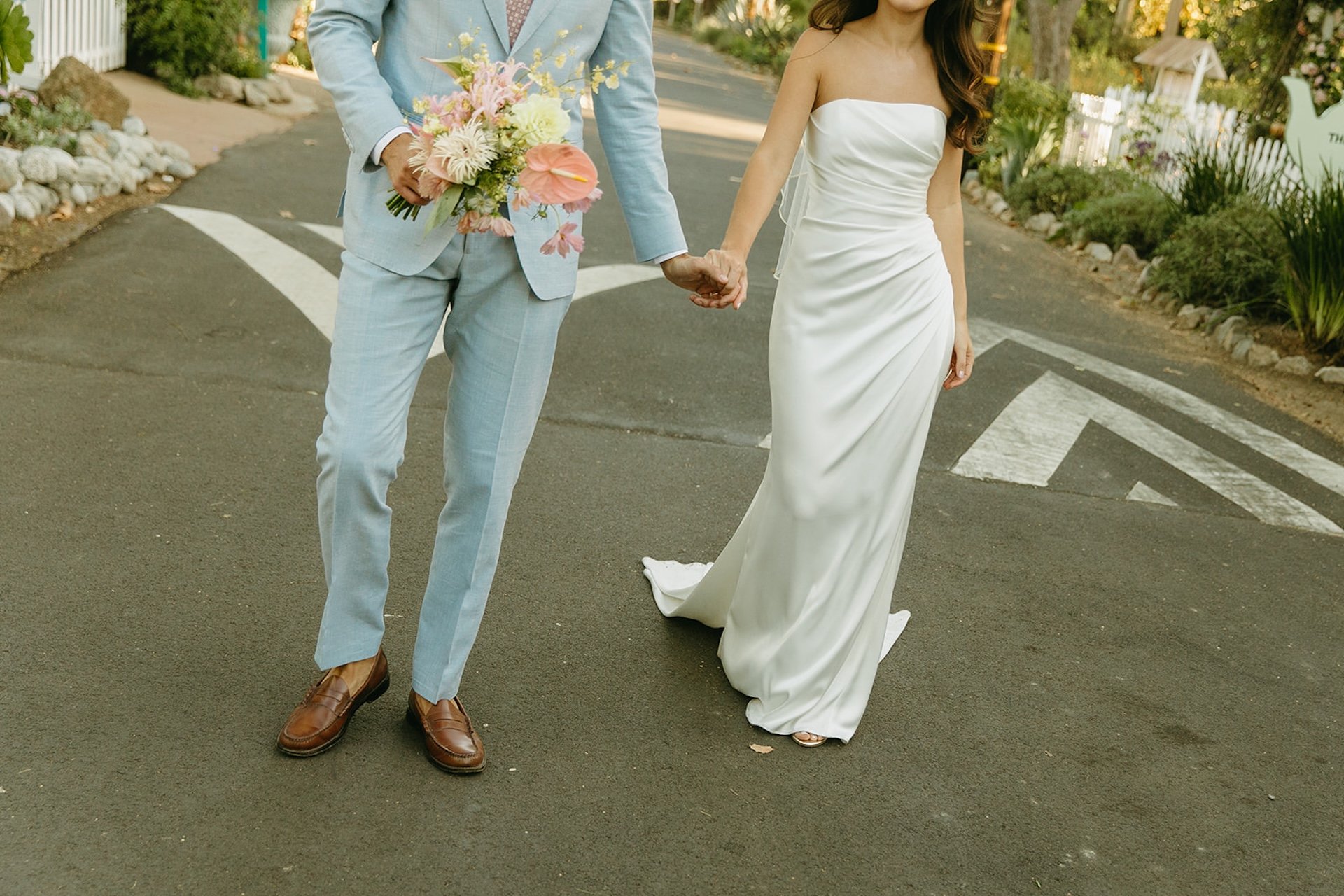 A close up of the bride and groom walking hand in hand during their bride and groom couple photos.