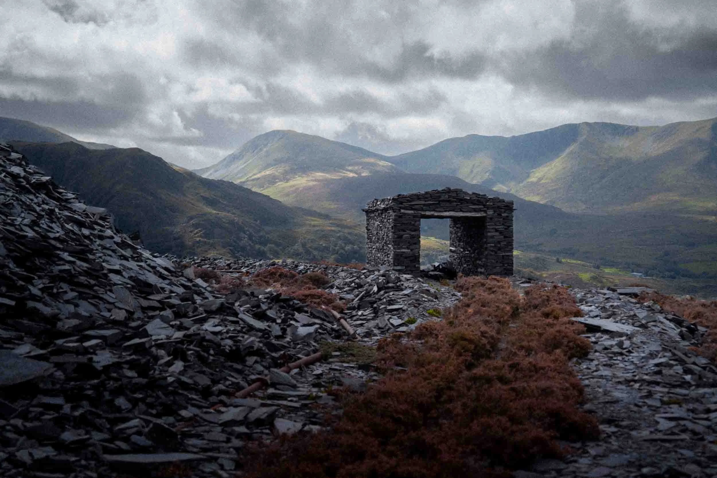 An abandoned cart shed overlooking the Yr Wyddfa Massif (Snowdon Massif) mountain range.
