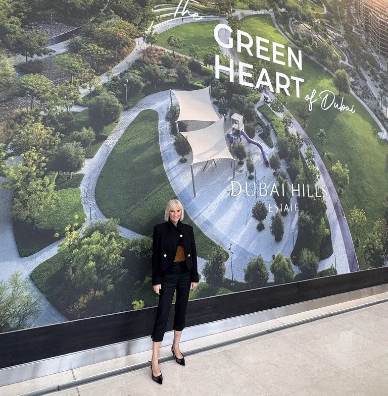 Sarah in front of a Dubai Hills masterplan render