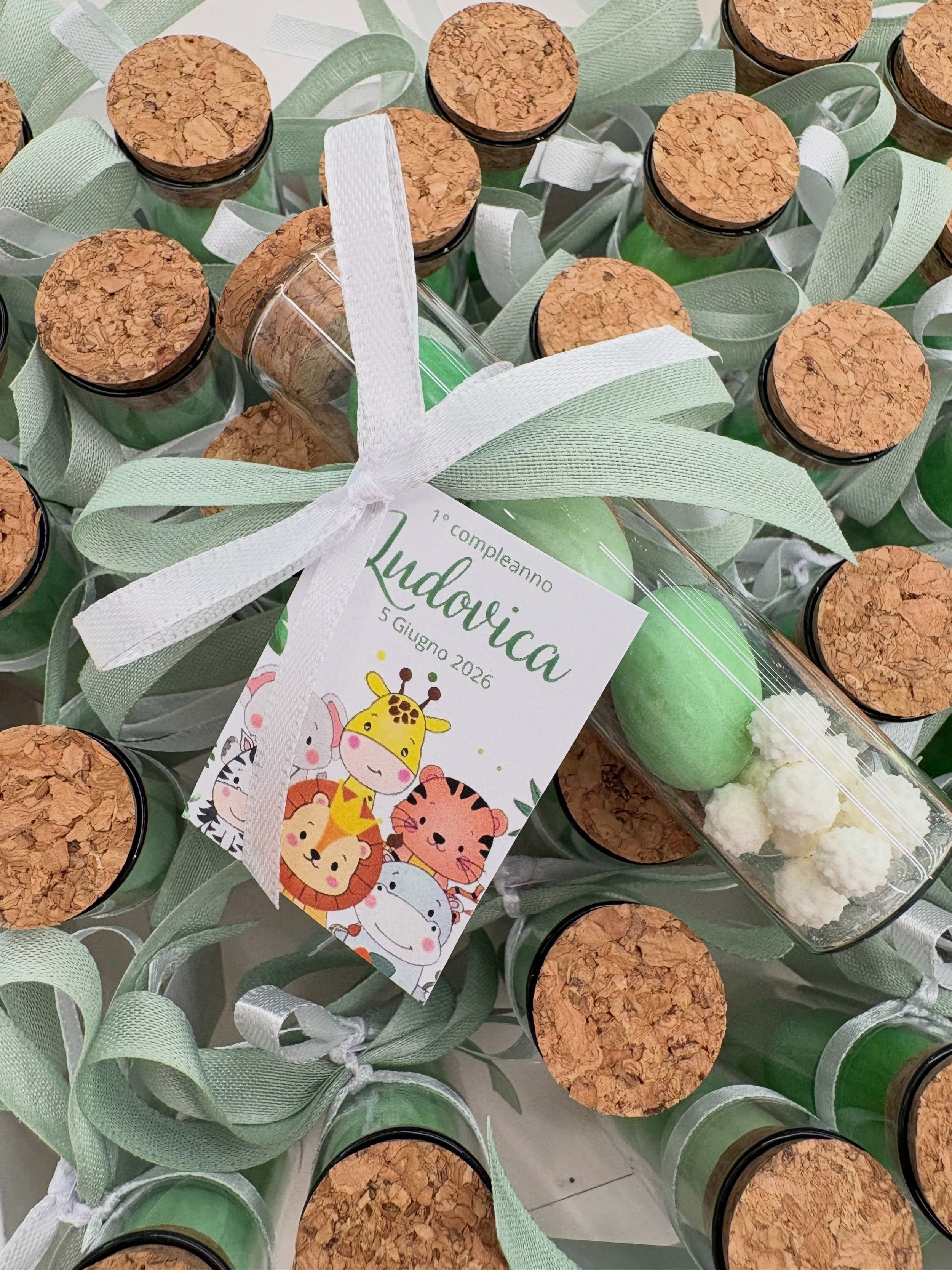 Per il primo compleanno della piccola Ludovica, una dolce fialetta di vetro con 3 confetti verdi (limone, pistacchio, ricotta e pera, cassata siciliana) e un simpatico bigliettino a tema animali 🐘🦁🦛🐯🦒