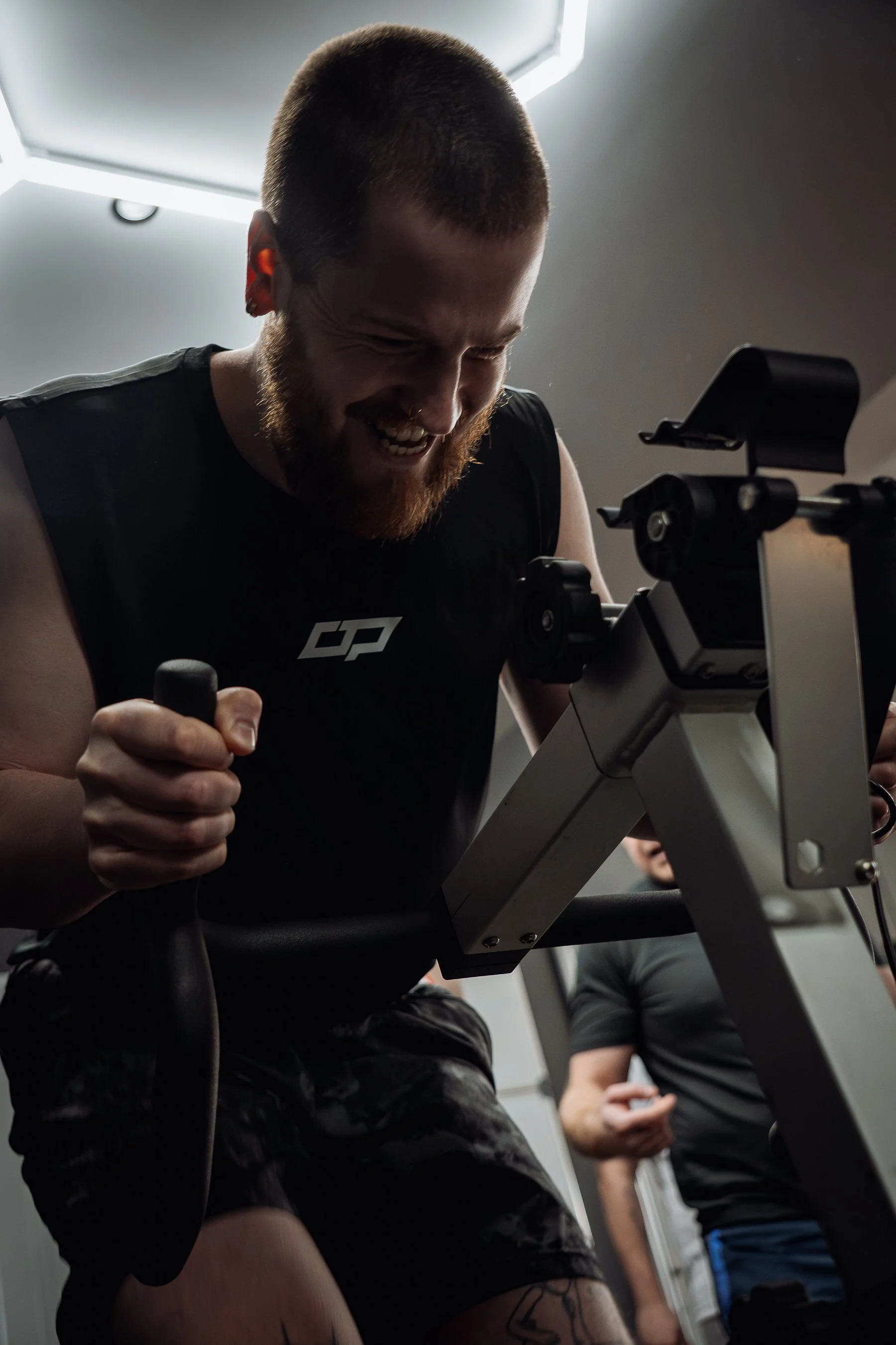 CTP Training member smiling while using the rowing machine during a workout session in Morpeth