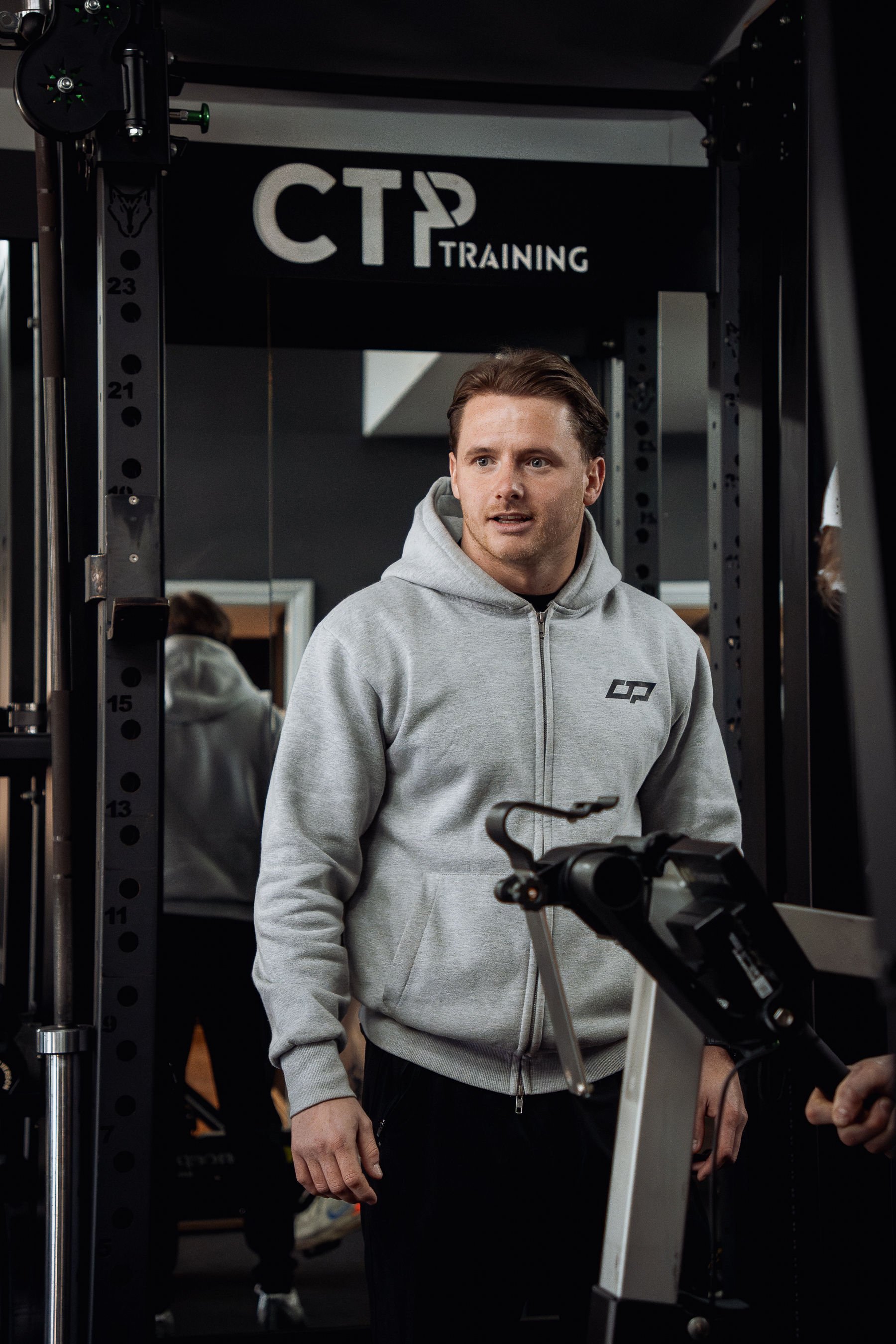 Head coach Craig at CTP Training gym in Morpeth, standing near workout equipment and gym training signage.