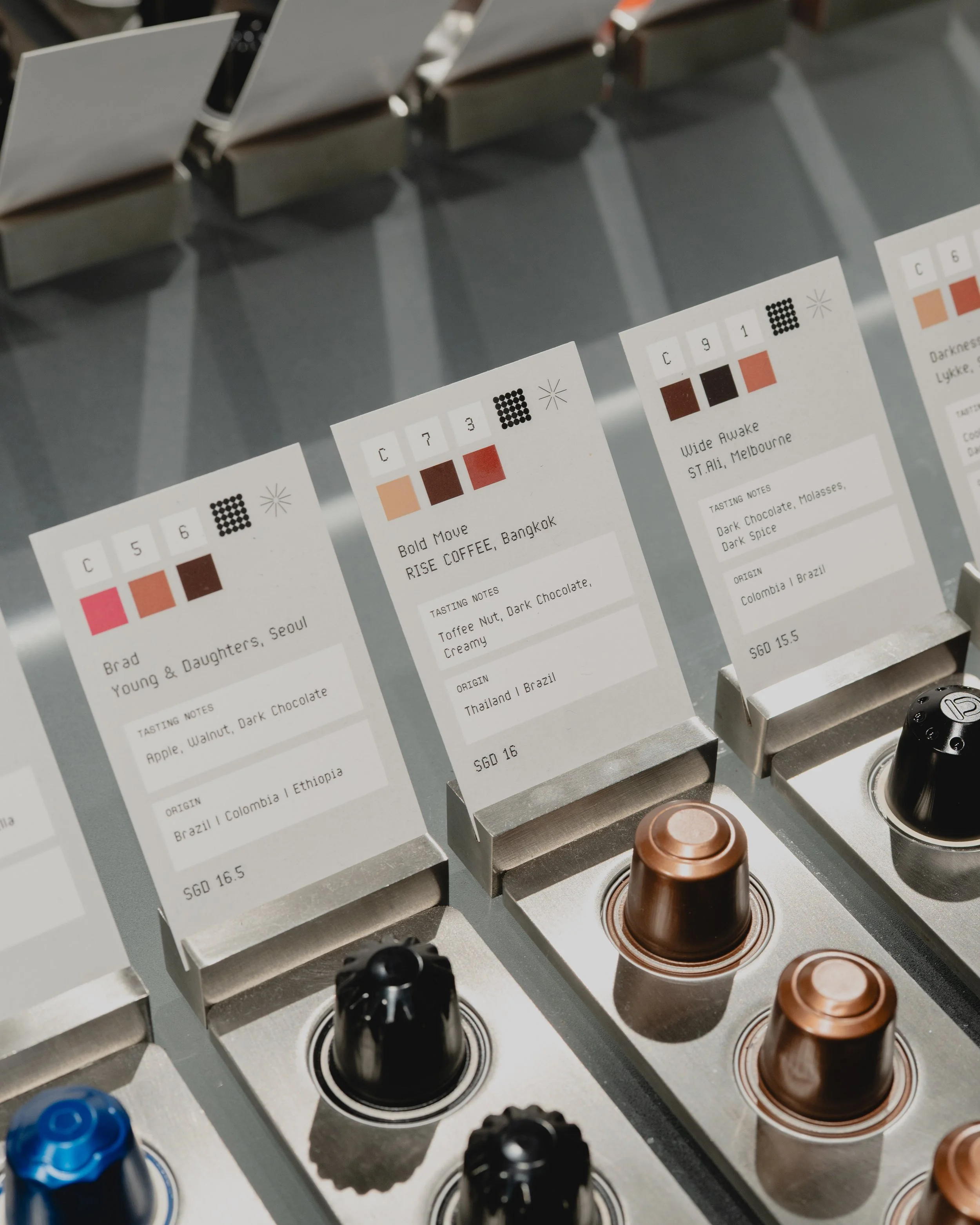 Coffee tasting notes cards and coffee capsules on a display at a coffee shop.