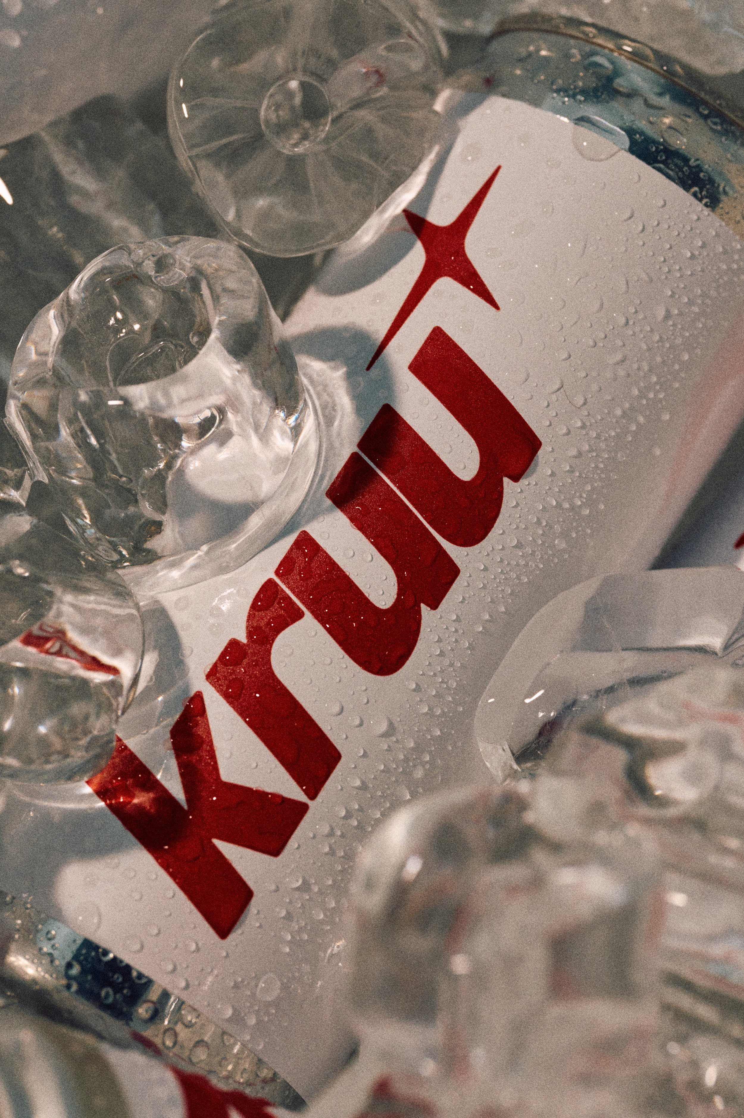 A can of Sprite with condensation on its surface surrounded by ice cubes and droplets of water.