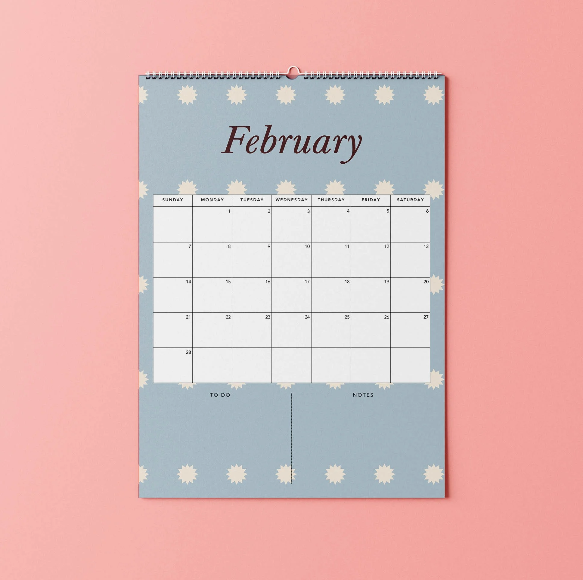 February 2027 page of the Sofe Store wall calendar with a dusty blue background, cream star pattern, a burgundy italic “February” heading and a large Sunday-to-Saturday date grid with To Do and Notes