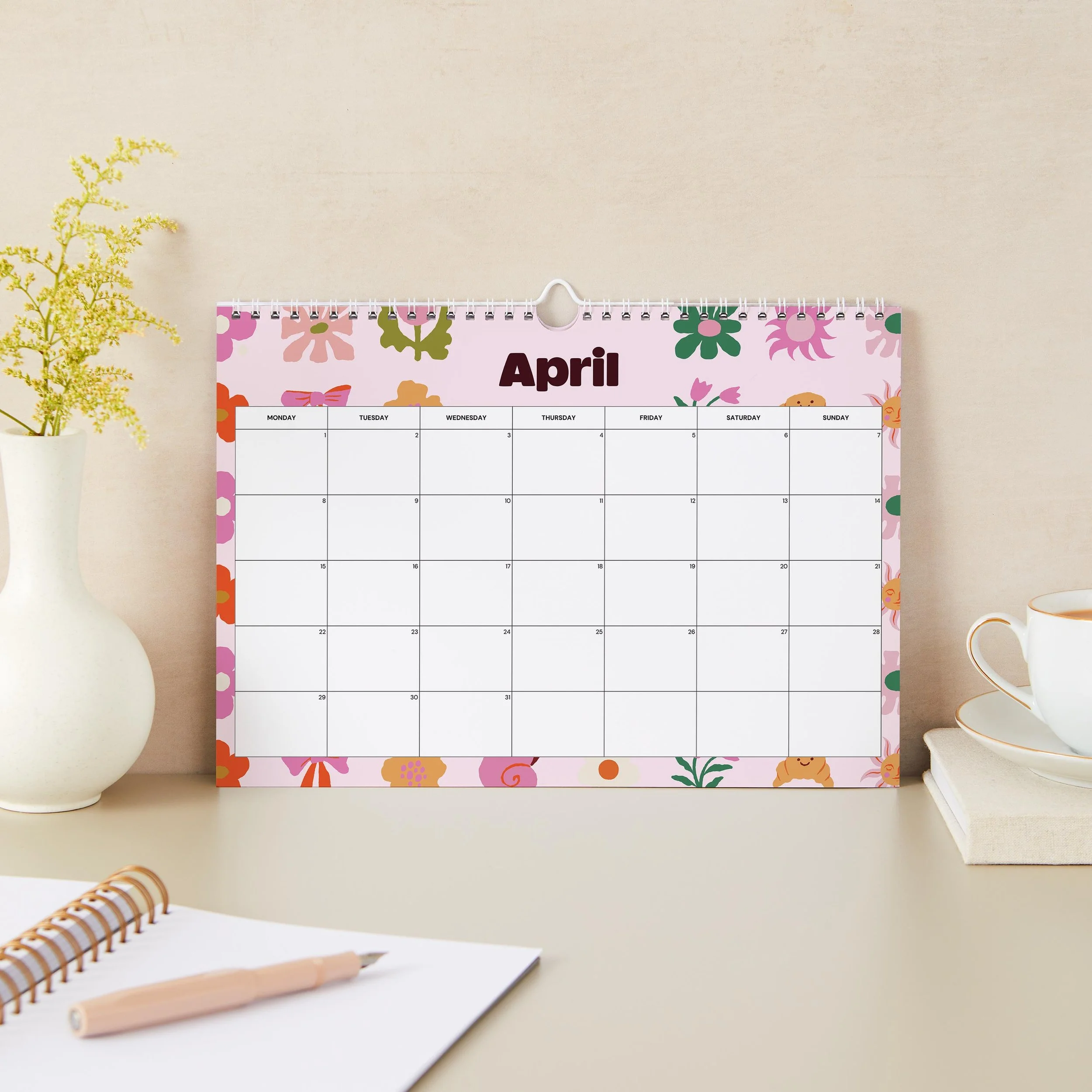 April 2027 page of the Sofe Store wall calendar with a pink floral border and a large Monday-to-Sunday date grid