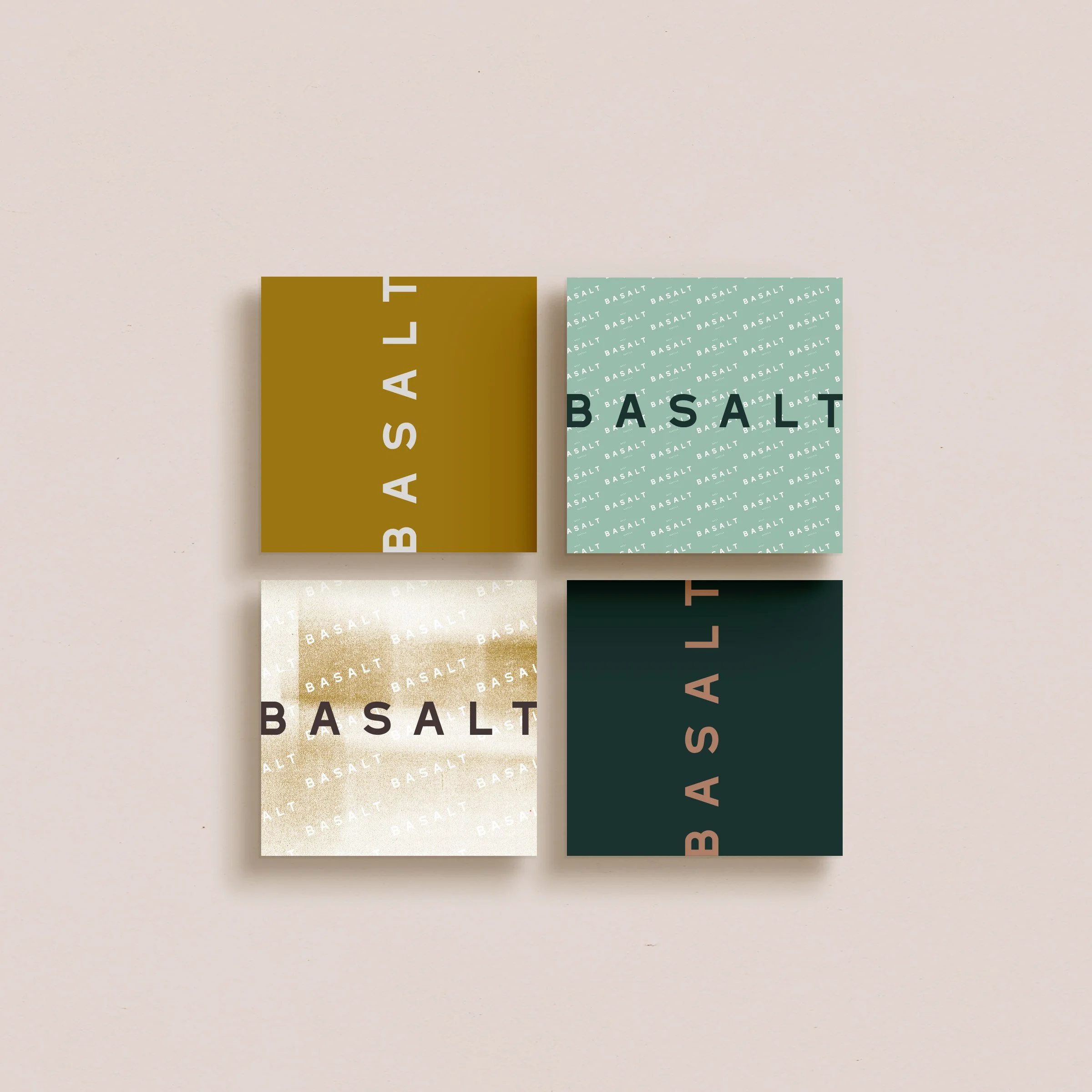 Four square cards with the word 'BASALT' on each. Each card has a different background color: mustered yellow, light teal with repeated 'BASALT,' creamy beige with repeated 'BASALT,' and dark green with 'BASALT' in pink.