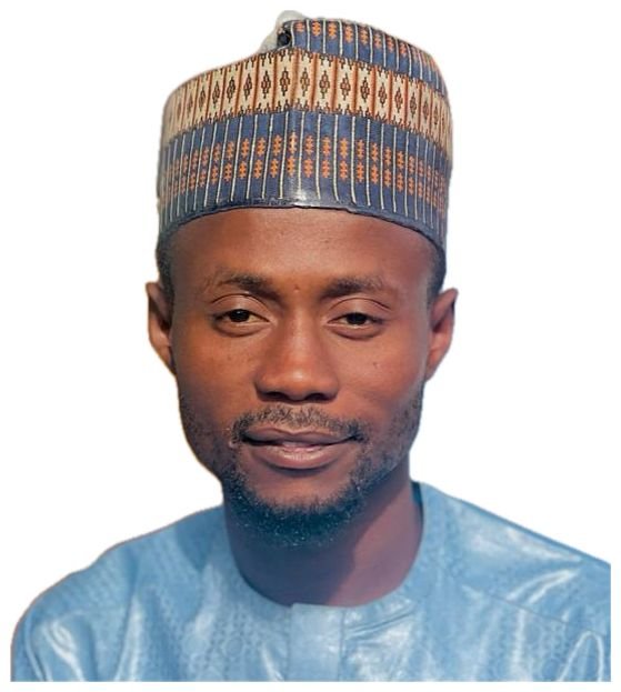 A man wearing a traditional cap and a shiny blue shirt, looking at the camera with a slight smile.