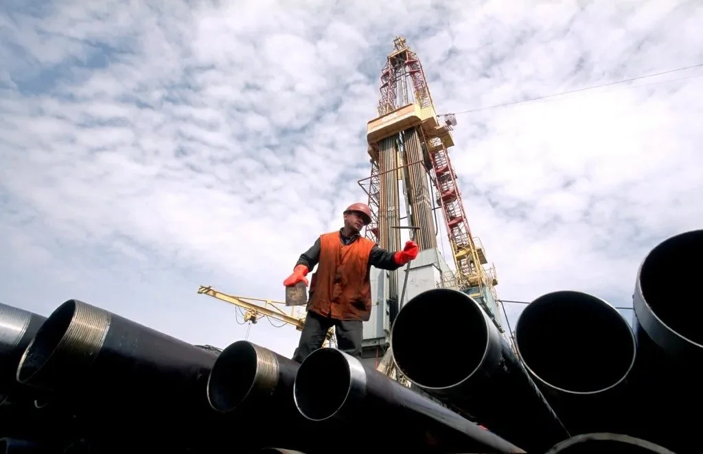 Man in safety gear standing on large pipes